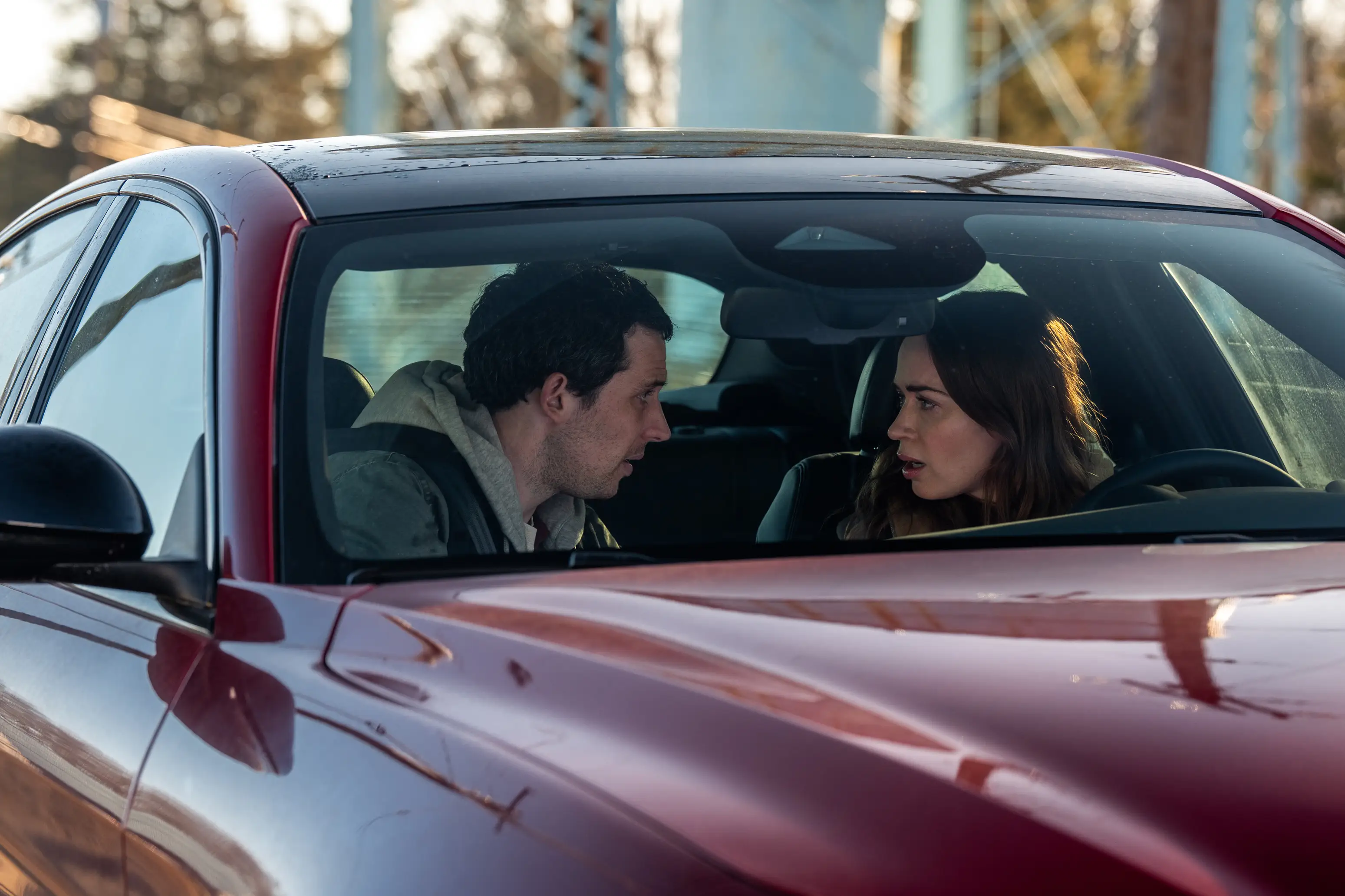 Josh O'Connor and Emily Blunt in a red car in Disclosure Day movie