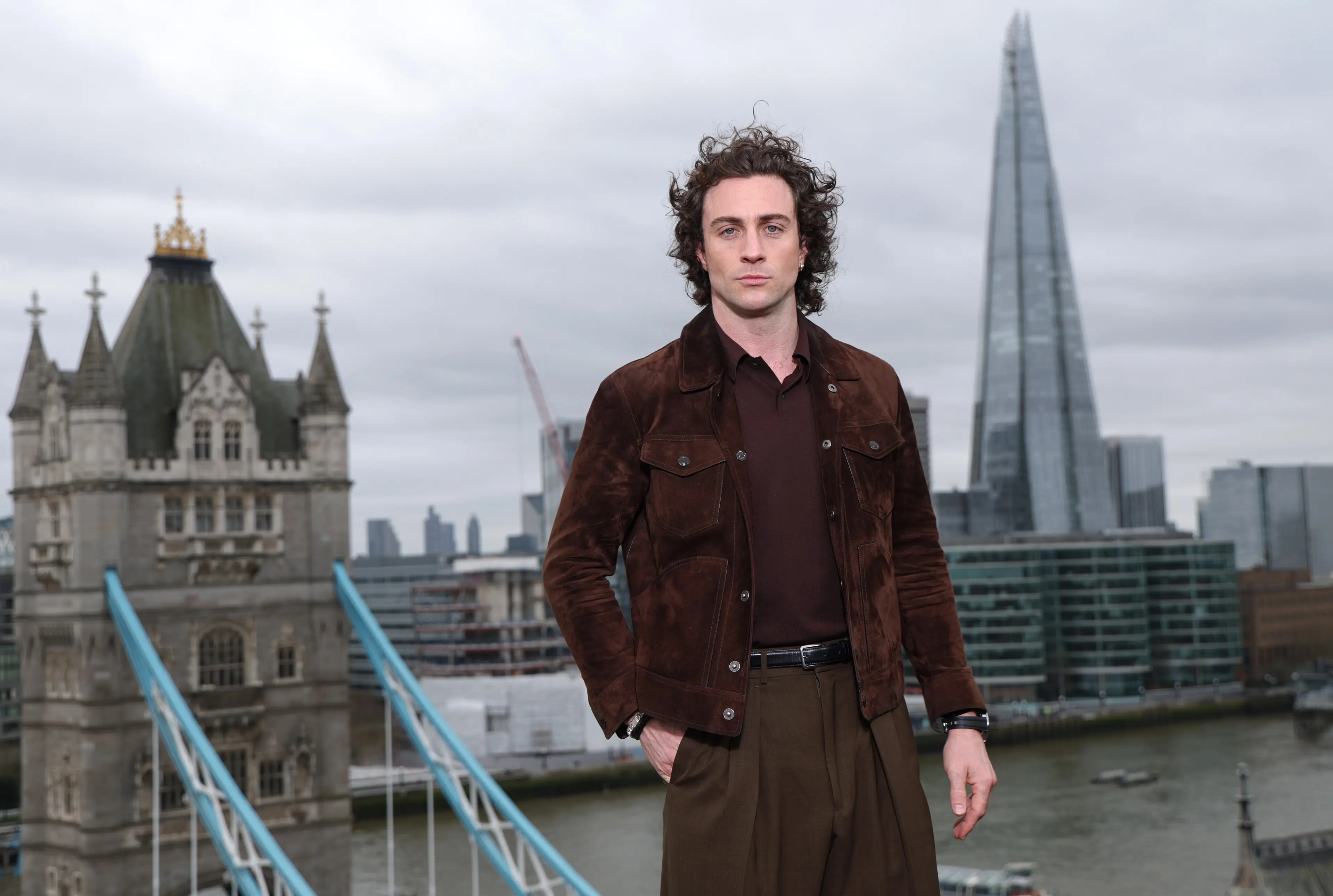 Aaron Taylor-Johnson posing on a rooftop