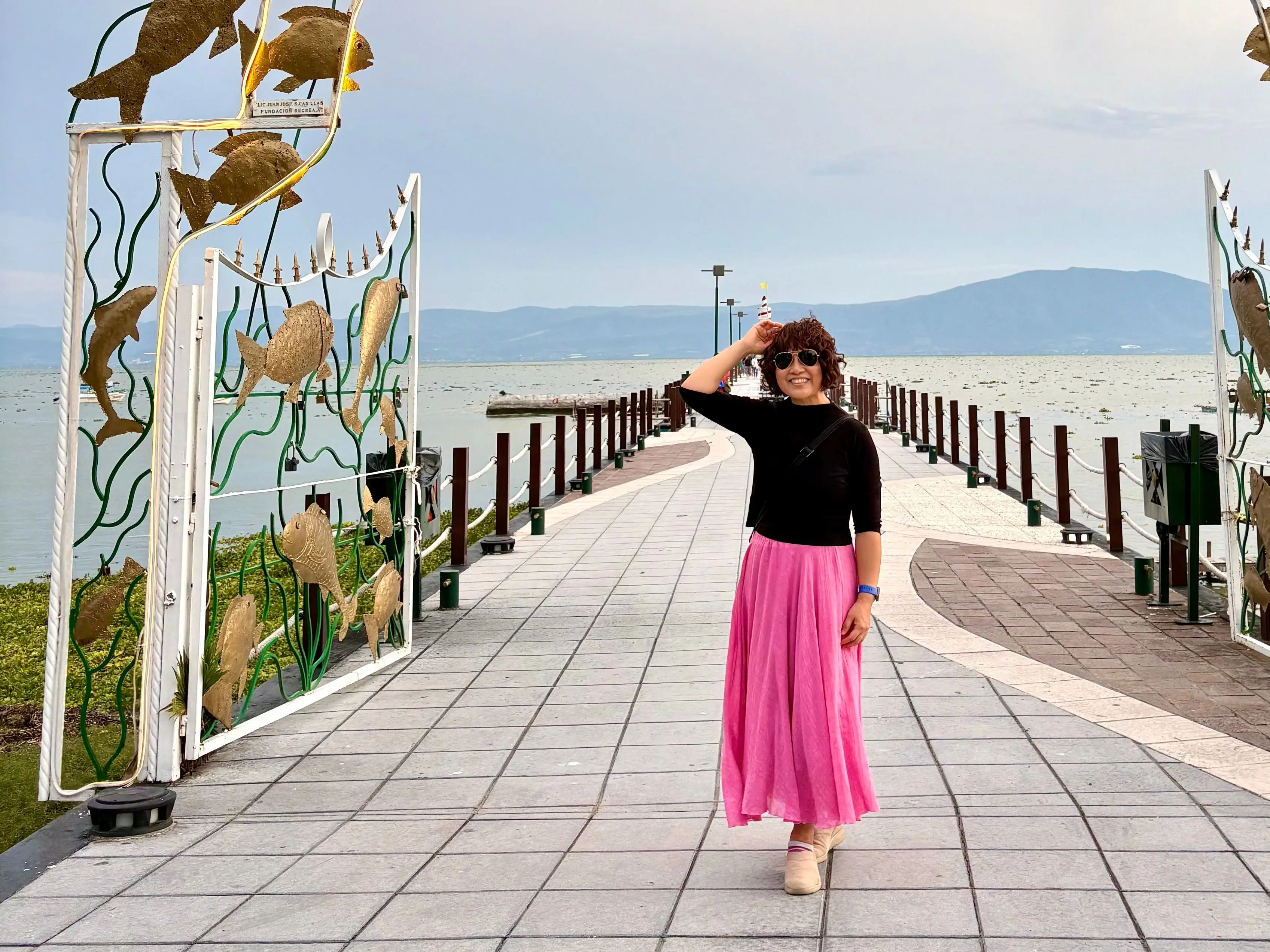 Woman posing below arch on pier