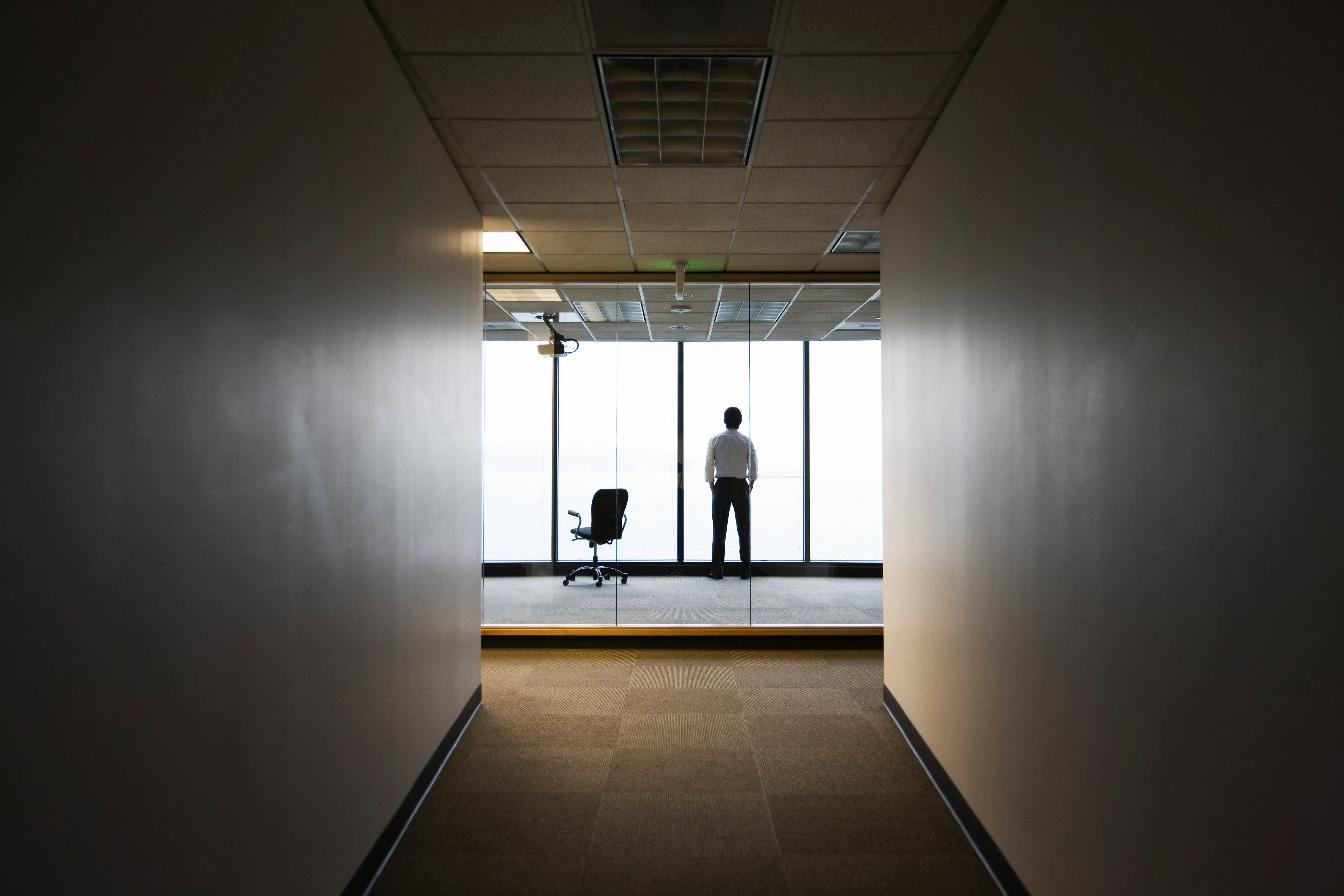 Man standing by a window in an office
