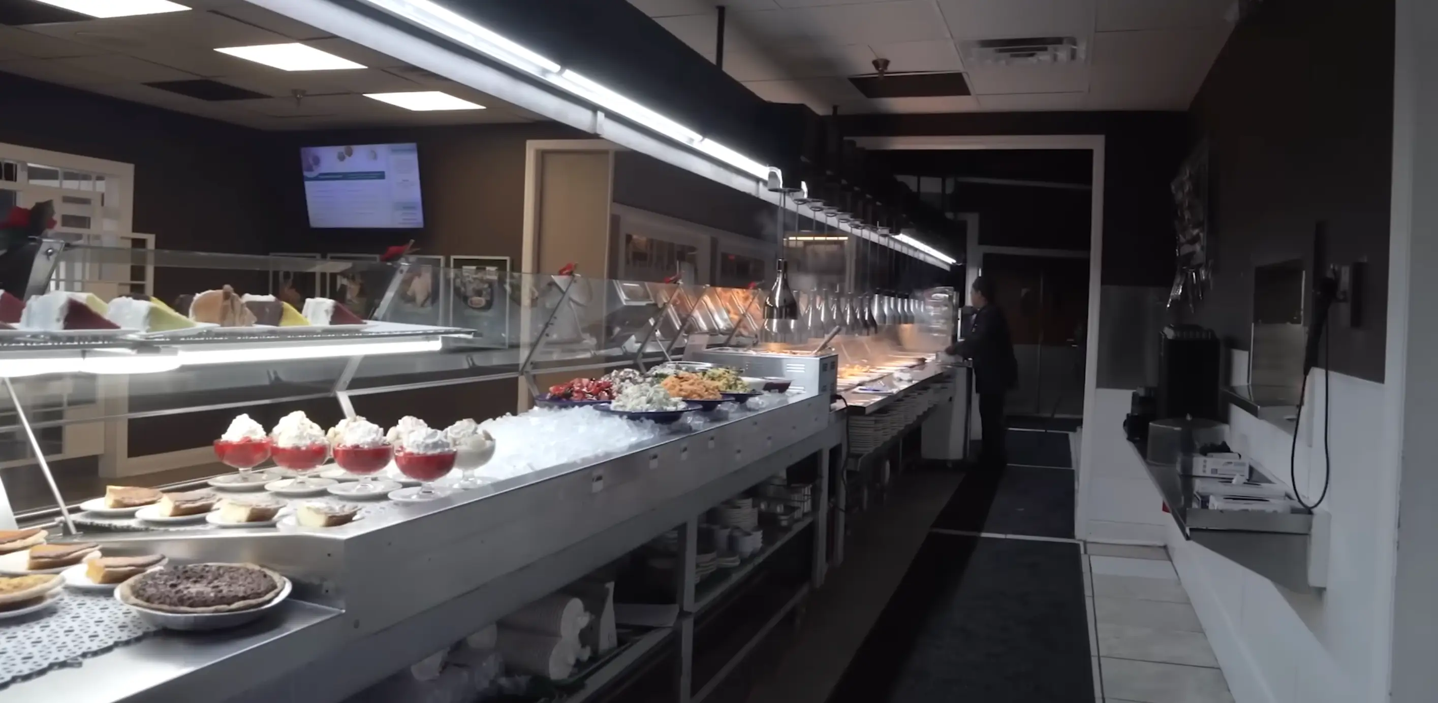 Long stainless steel cafeteria serving line.