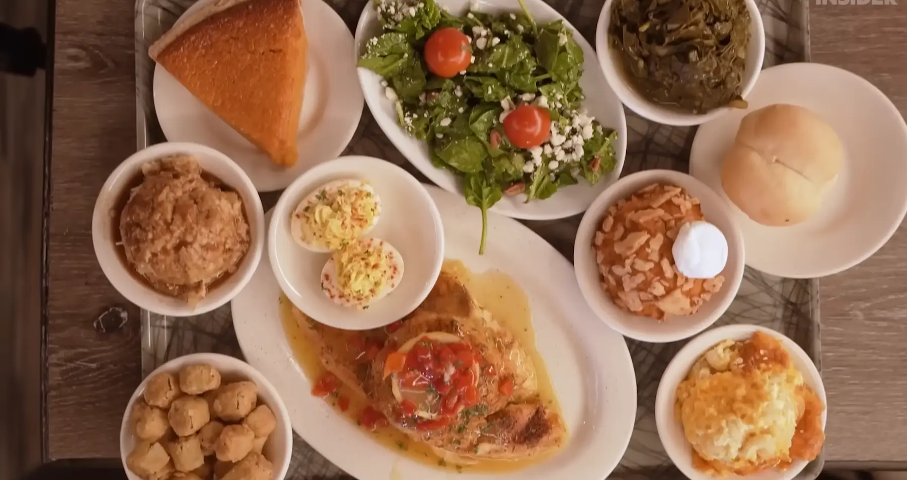 Overview shot of salad, pie, collard greens, bread roll, catfish, deviled eggs, fried okra, and other food from Magnolia Room Cafeteria.