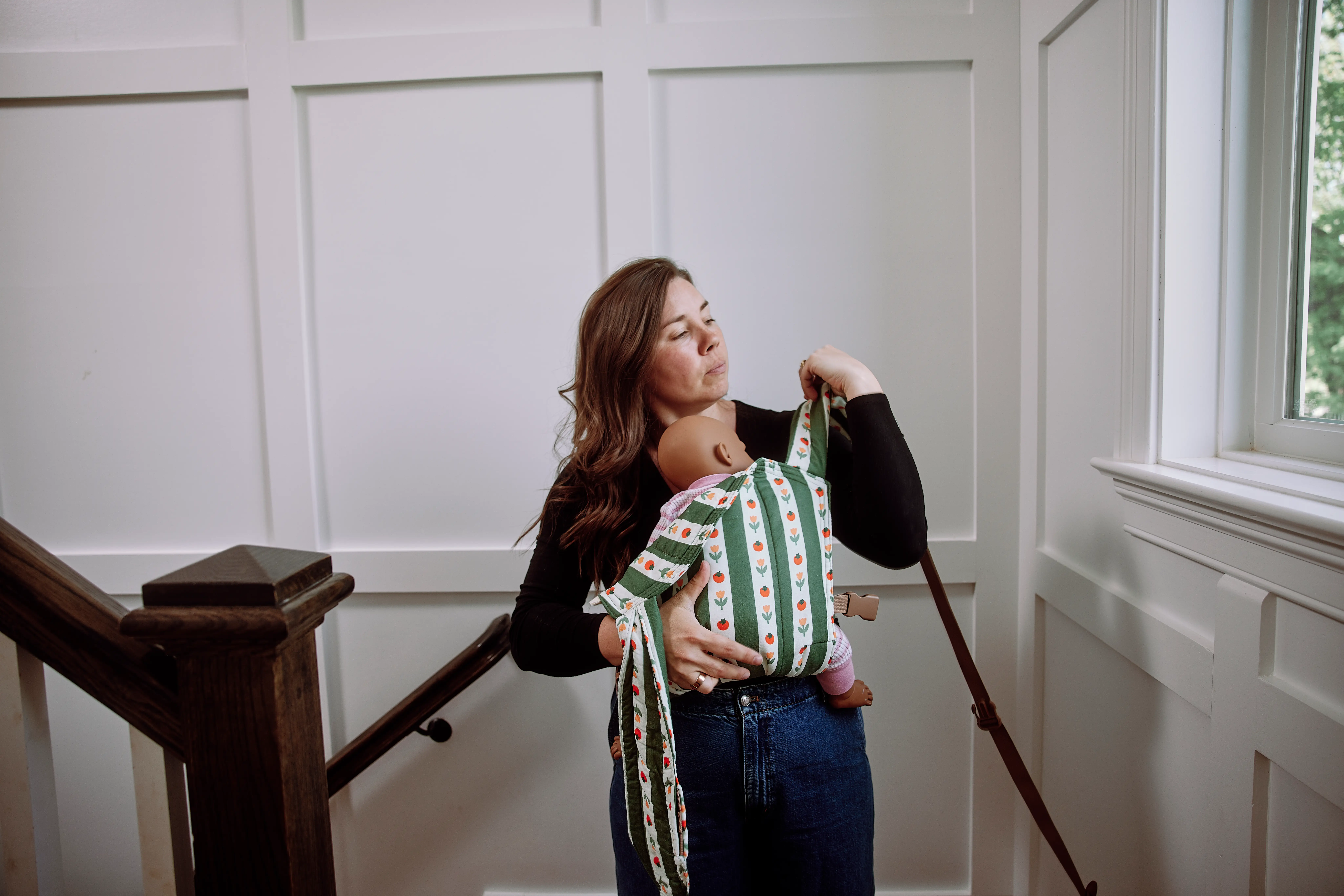 Skye demonstrates her buckle baby carrier in her home.