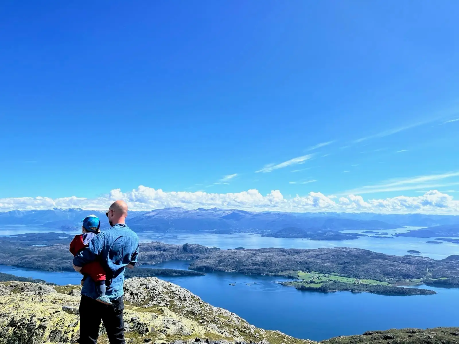 Man holding child in front of views of wa