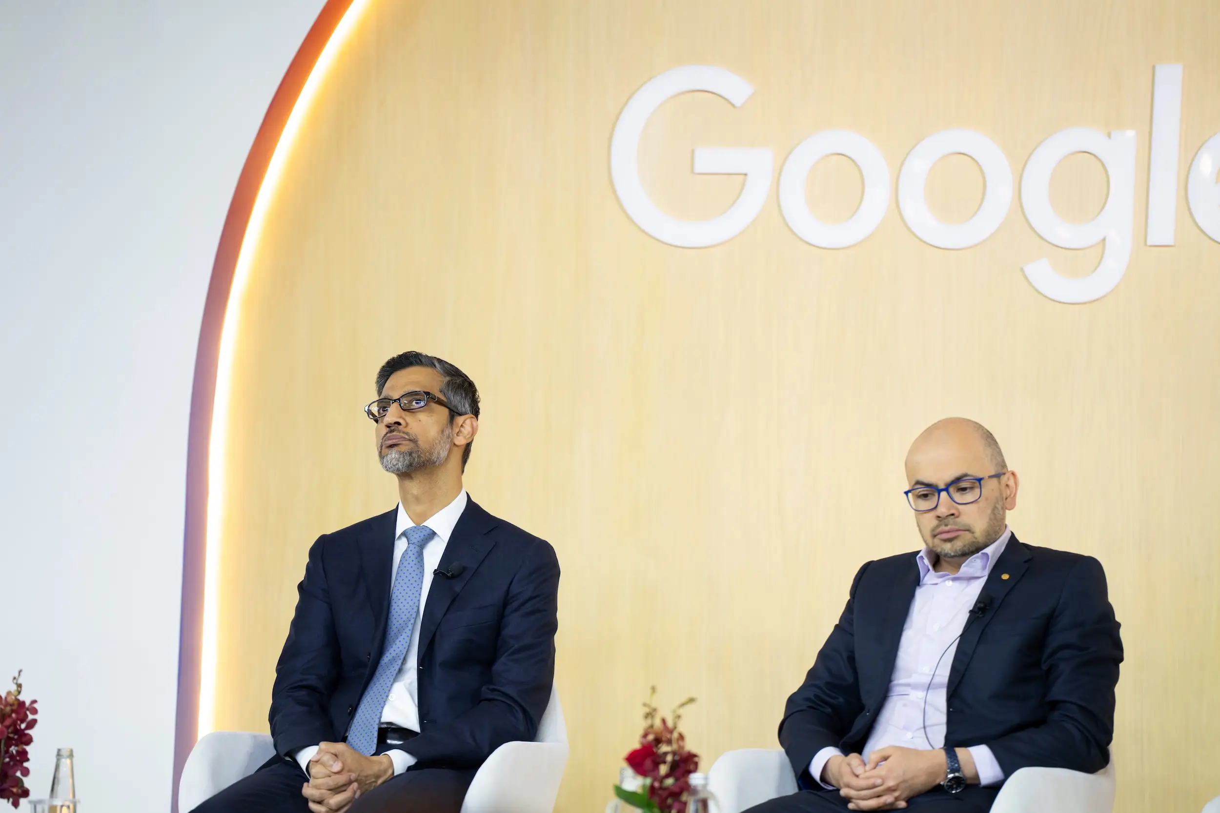 Sundar Pichai and Demis Hassabis sit on stage during an event