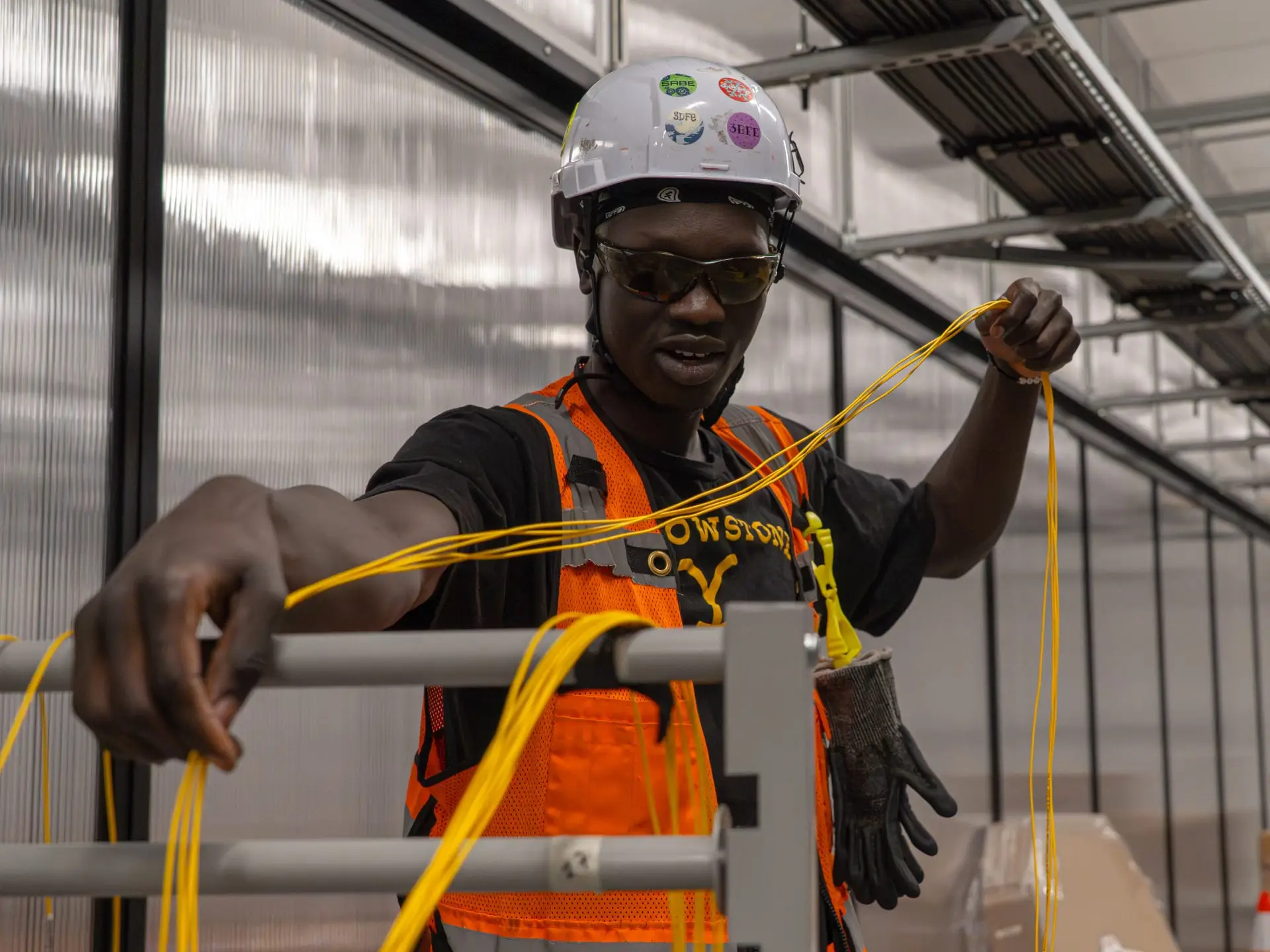 A fiber technician pulls cable at a data center.