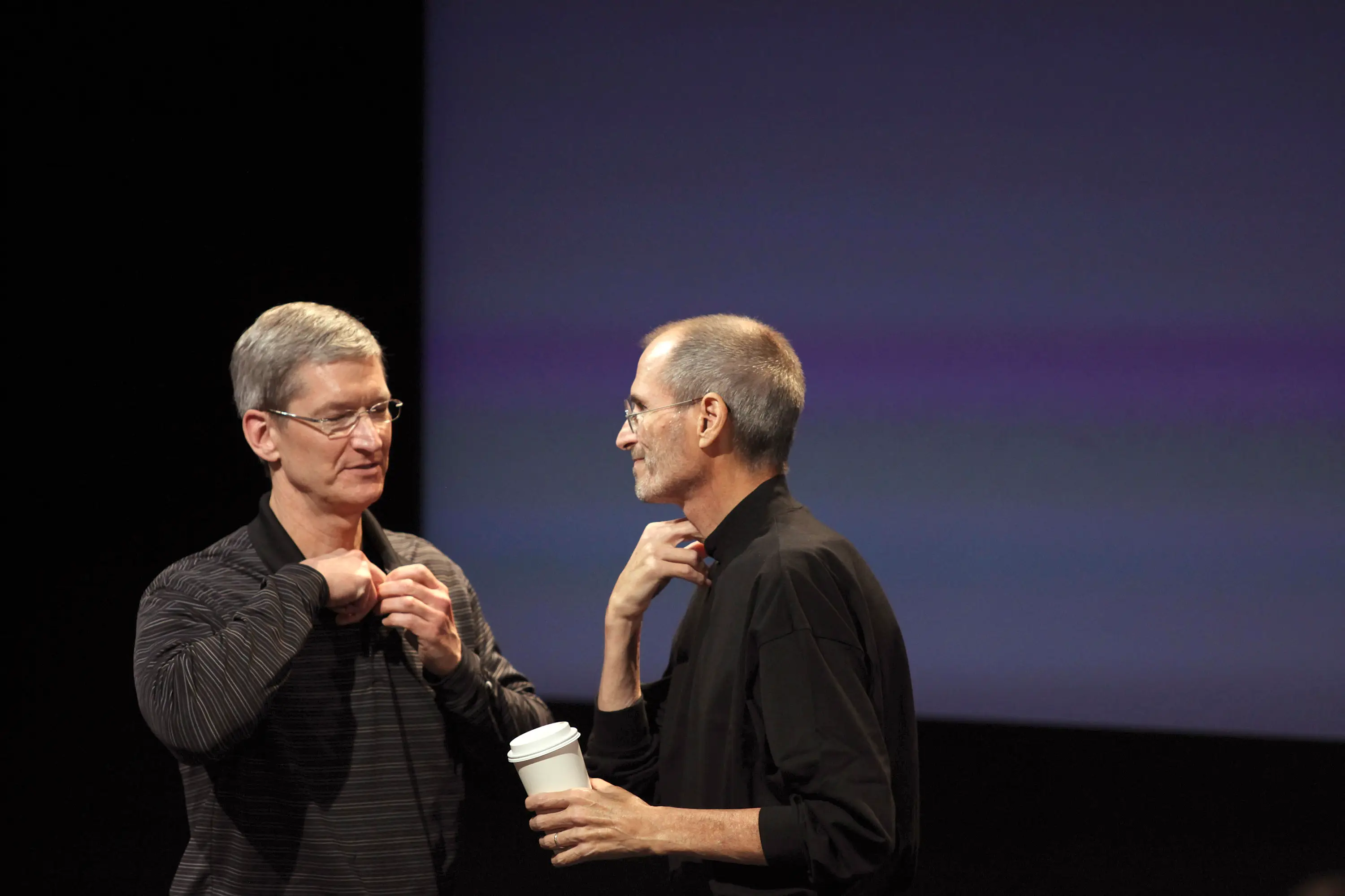 Apple COO Tim Cook (L) and CEO Steve Jobs remove their microphones after a news conference at Apple headquarters in Cupertino, California, July 16, 2010.