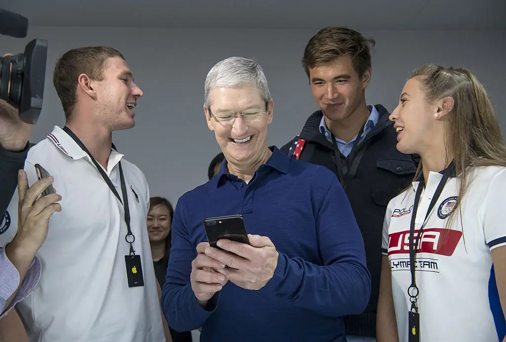 Tim Cook holds and iPhone.