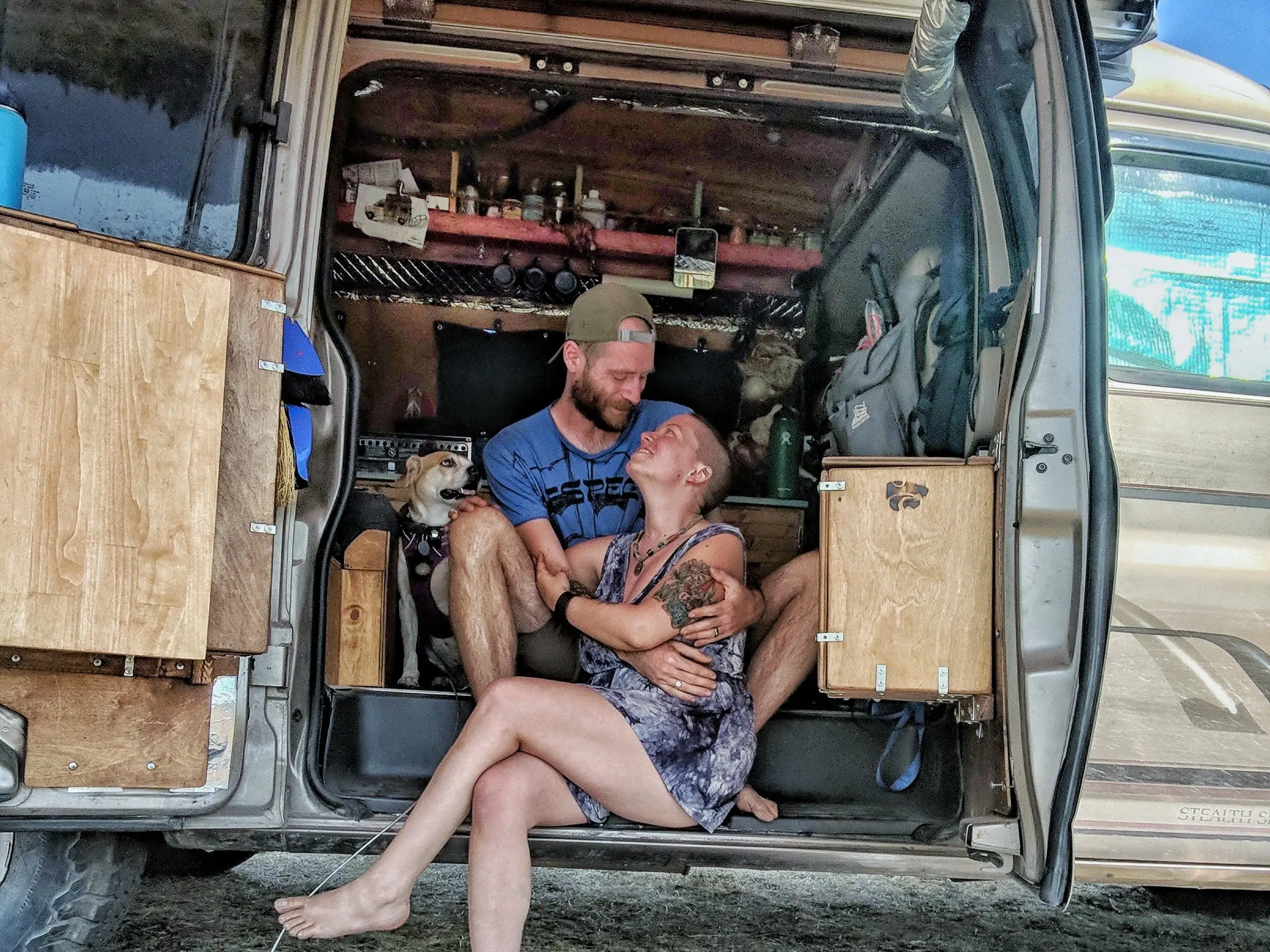 Jayme Serbell and her partner sitting in their camper van with their dogs