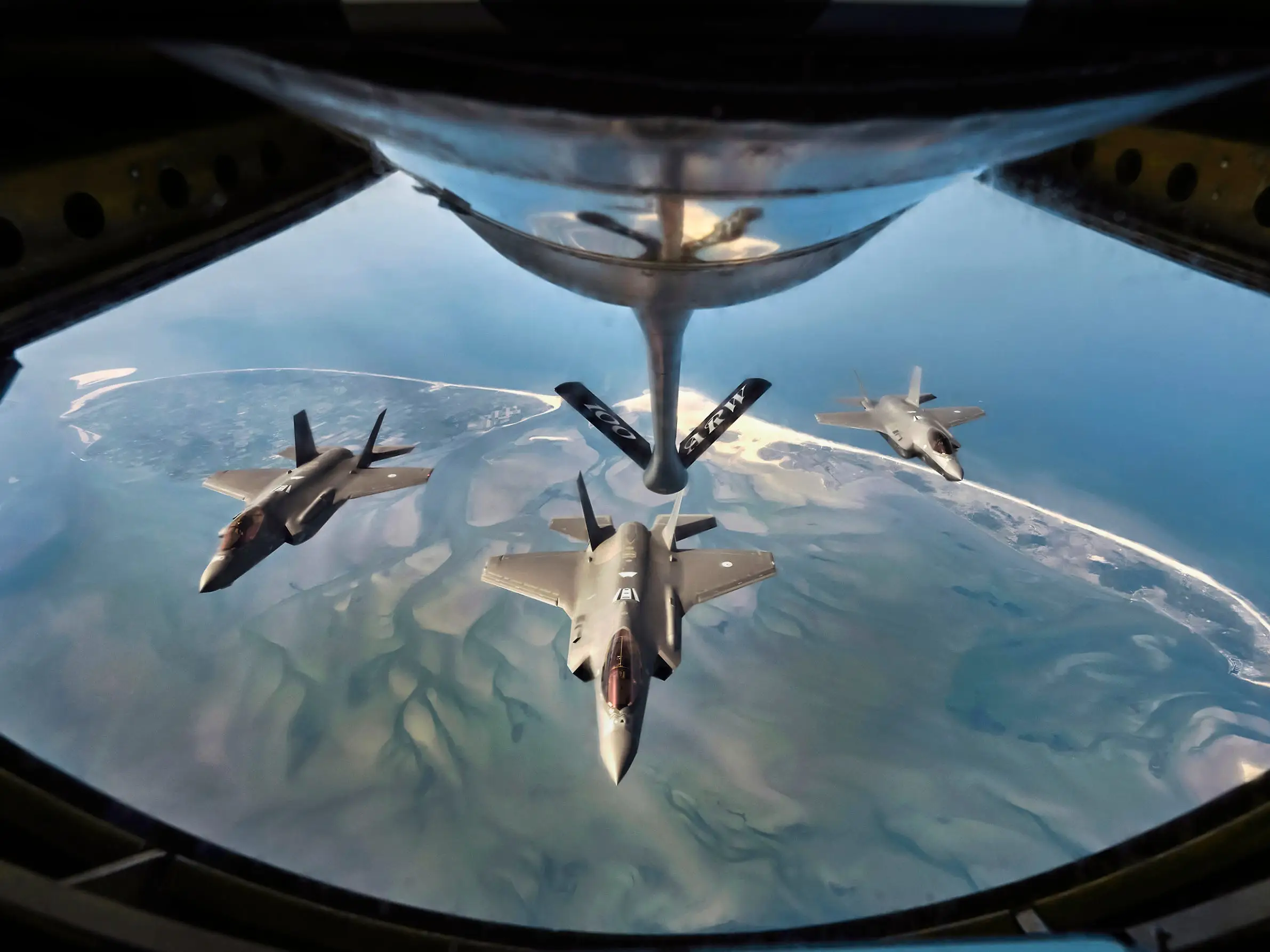 F-35 fighter jets of the Royal Netherlands Air Force in formation above the Wadden Sea.