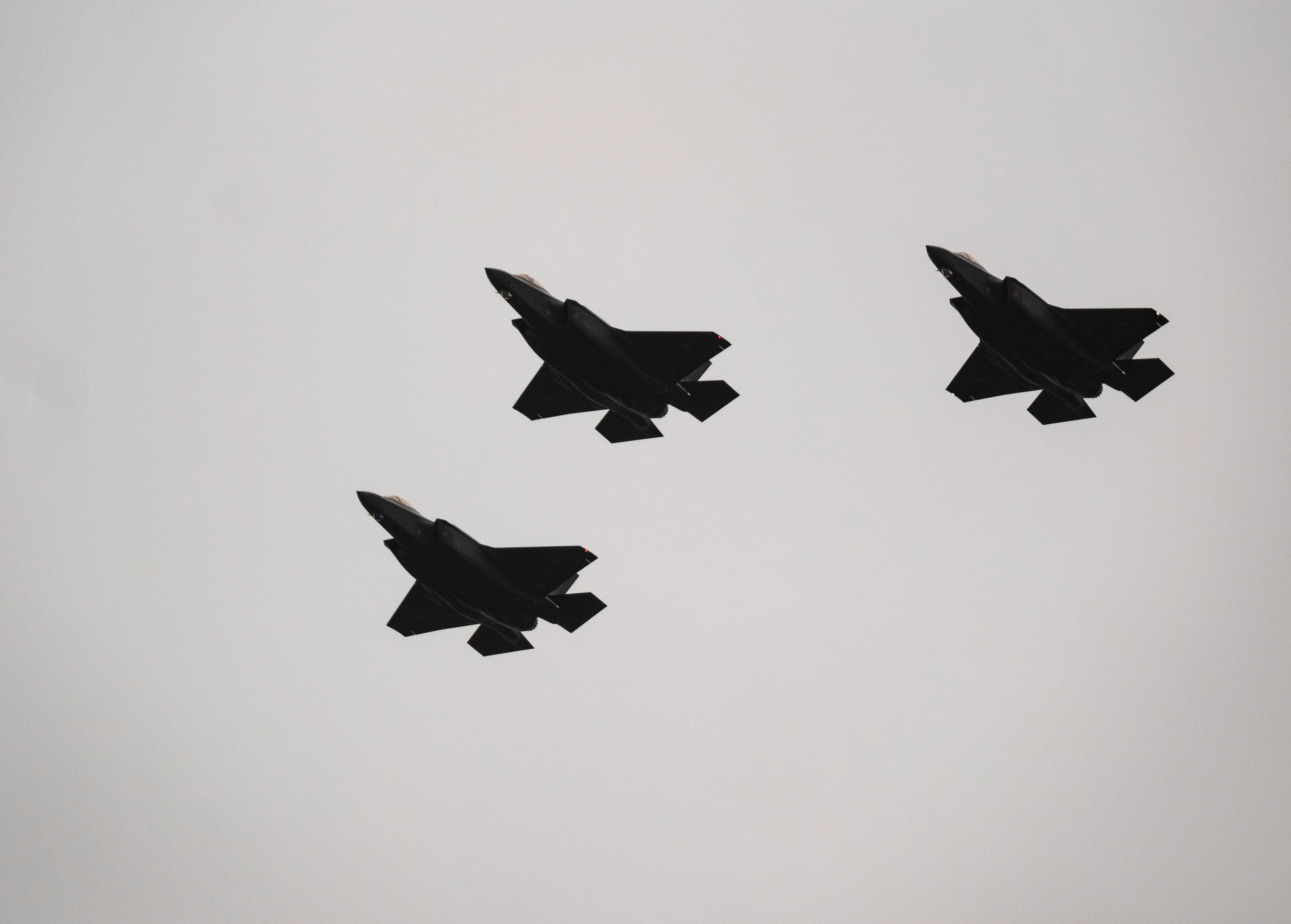 Three F-35 fighter jets flying in the air.