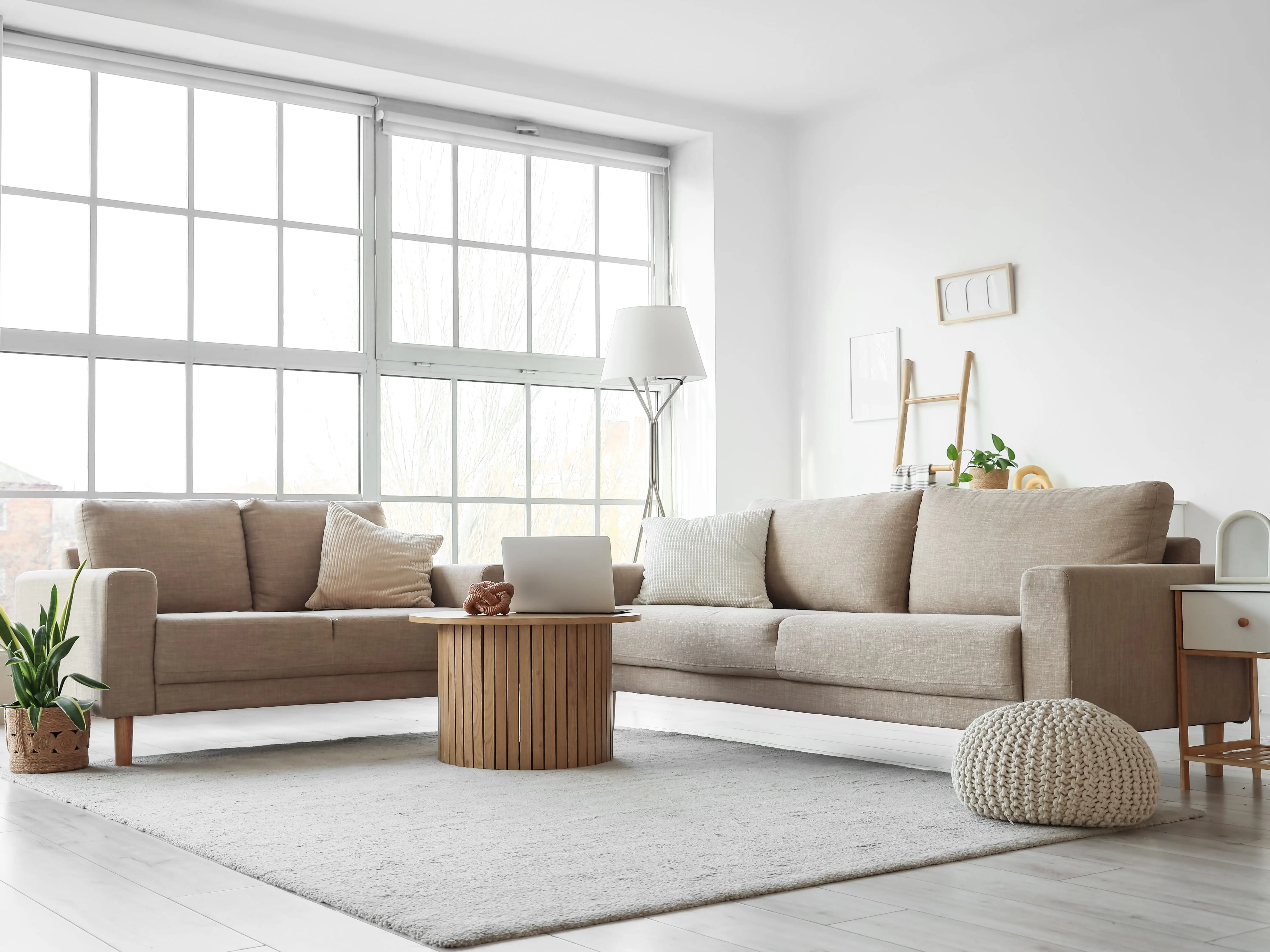 A white living room with beige couches and simple decor.