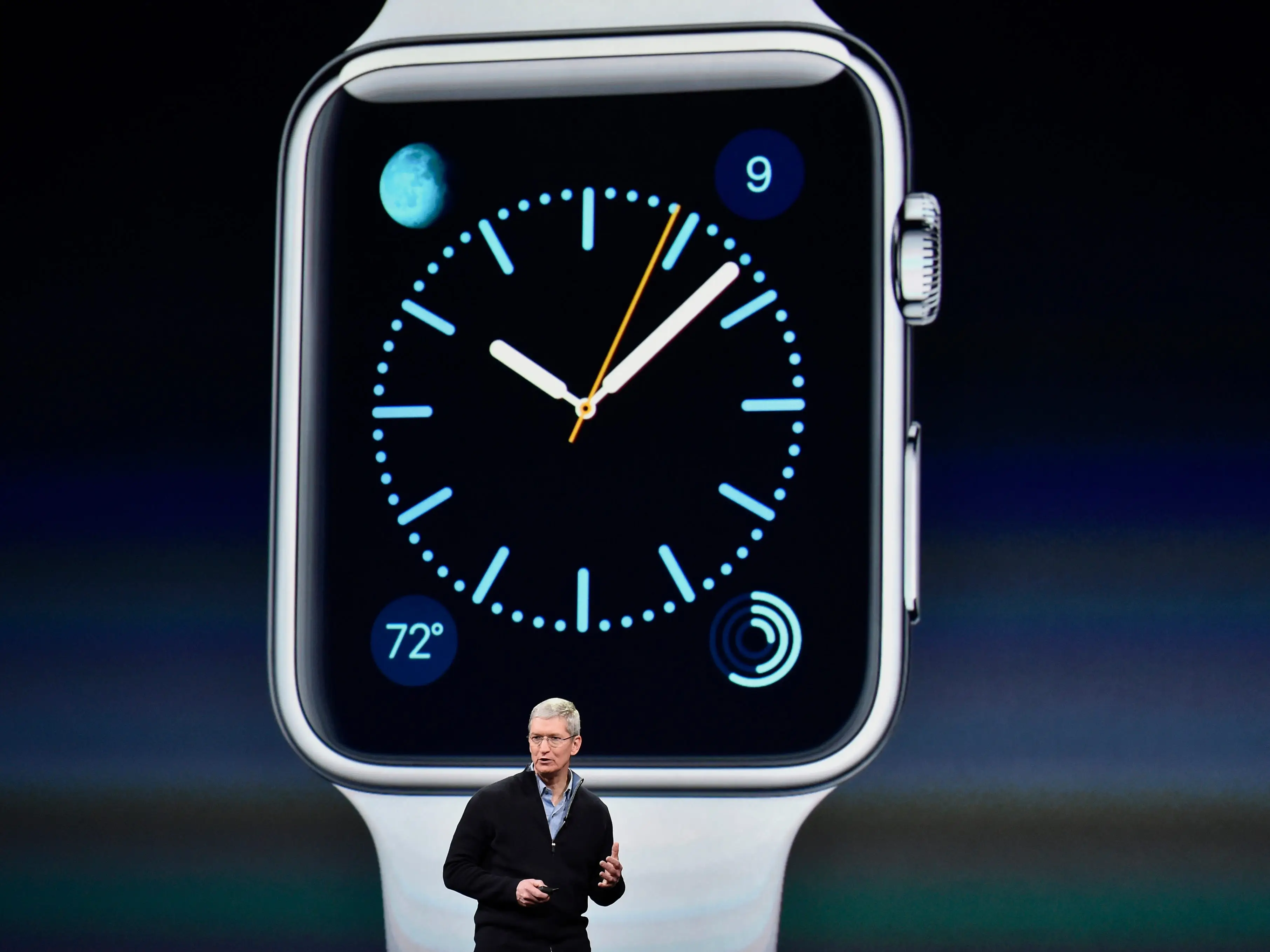 Tim Cook giving a presentation in front of an Apple Watch on screen behind him.