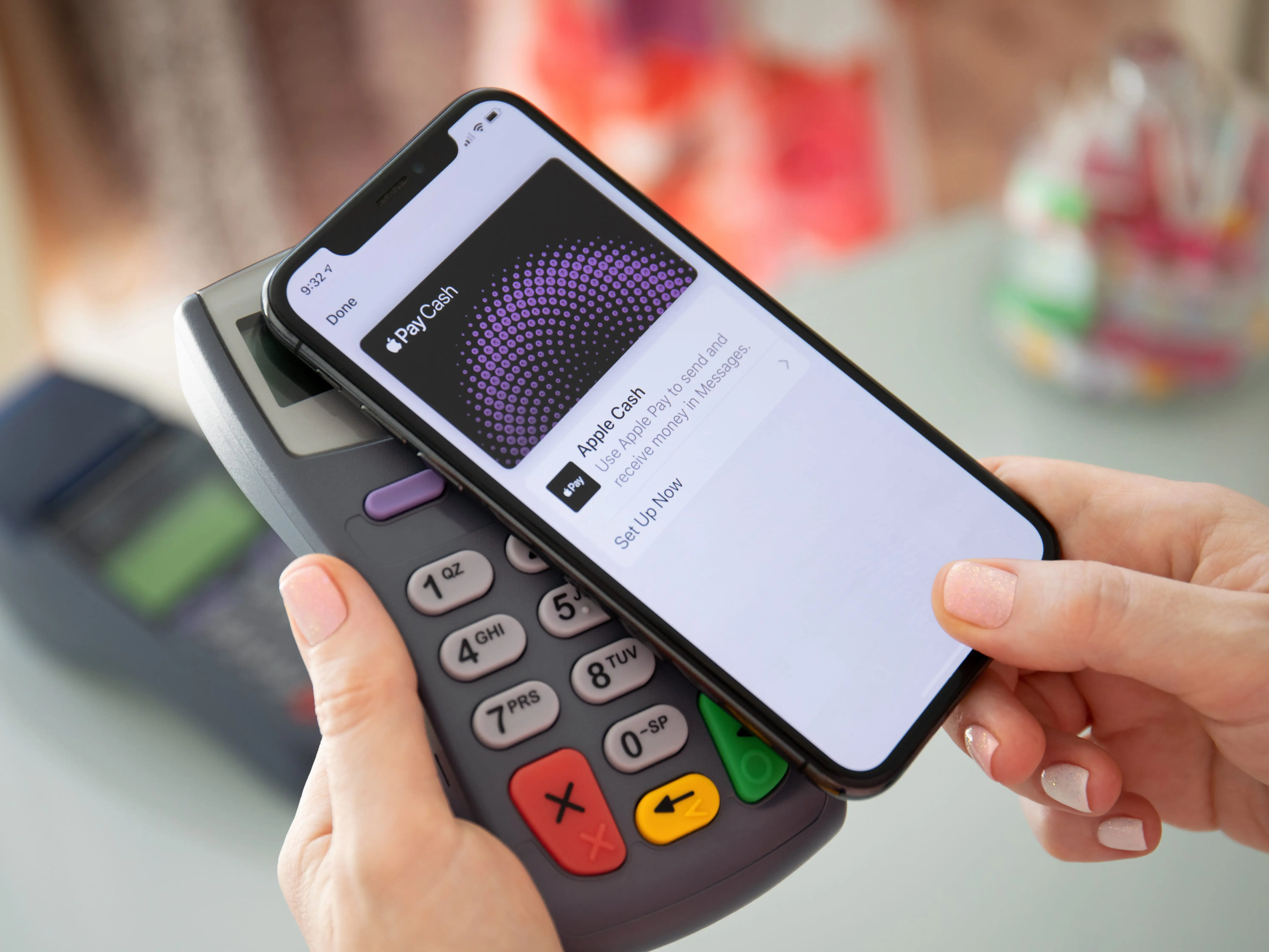 A phone holds up Apple Pay to a payment machine.