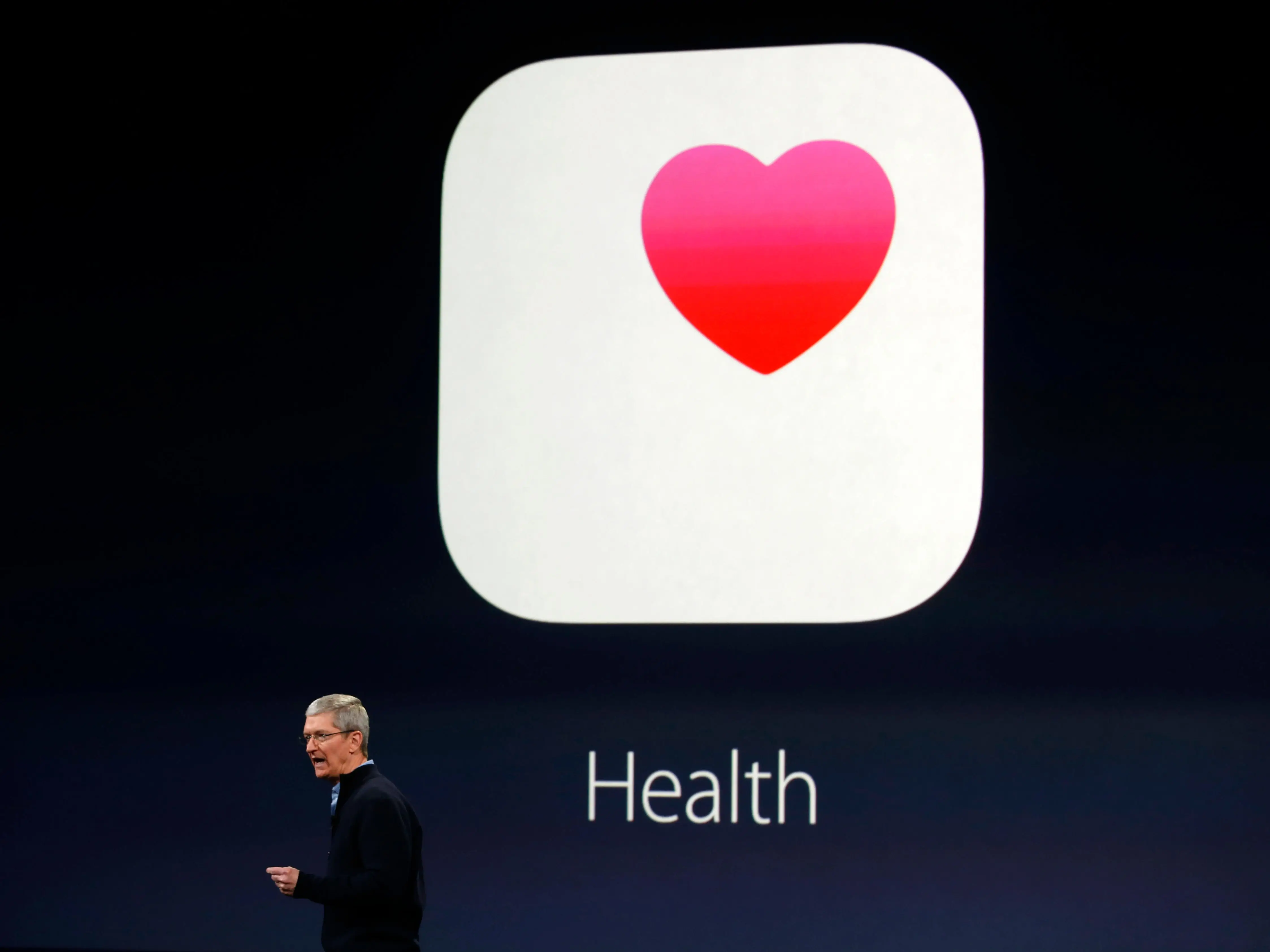 Tim Cook giving a presentation with the health app on screen behind him.