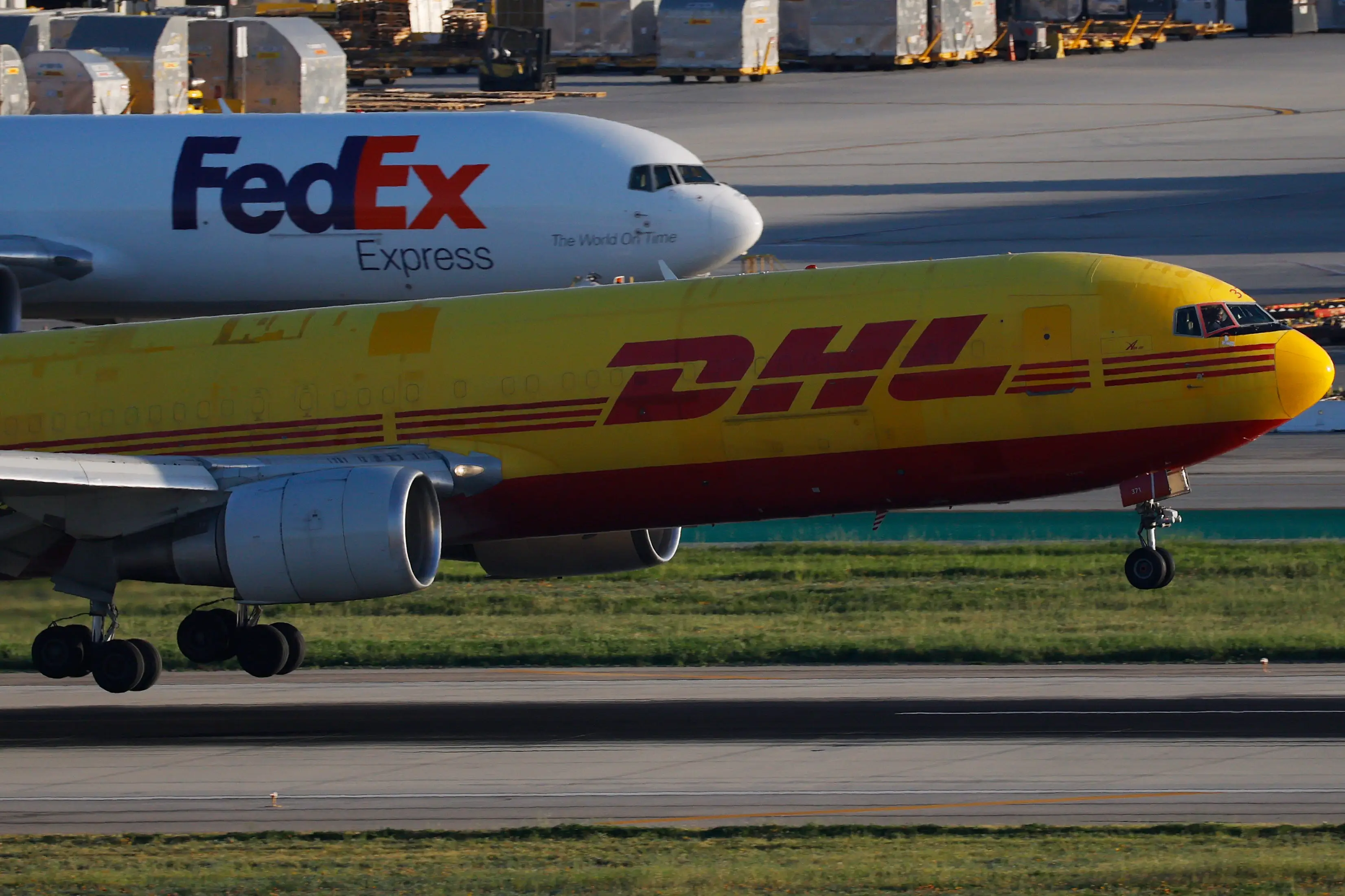 A DHL Boeing 767 airplane operated by ABX Air lands at Los Angeles International Airport from Cincinnati as a FedEx aircraft is parked on January 29, 2026 in Los Angeles, California.
