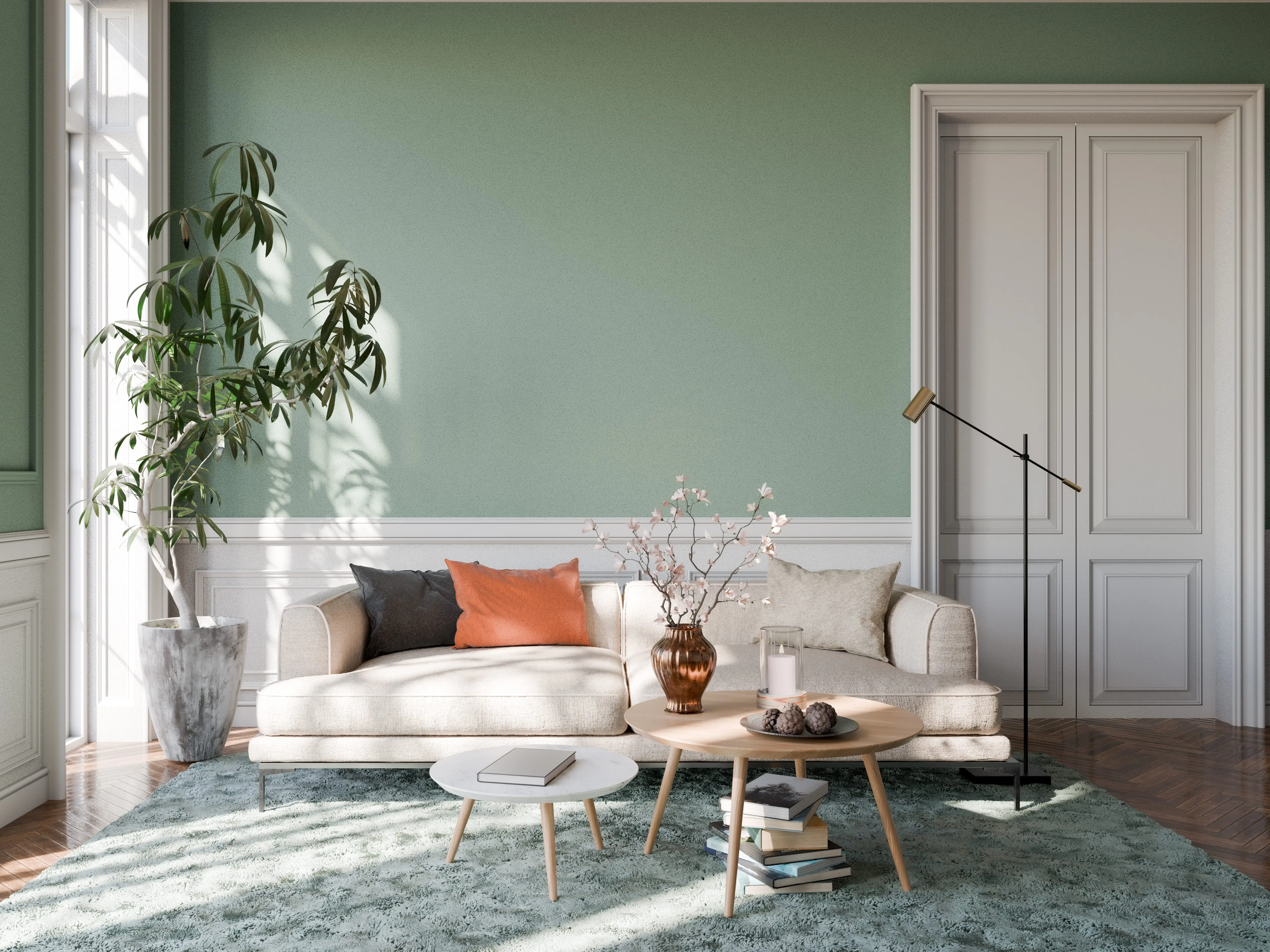 A living room with sage-green walls and carpet, a plant, and a couch with colorful pillows.