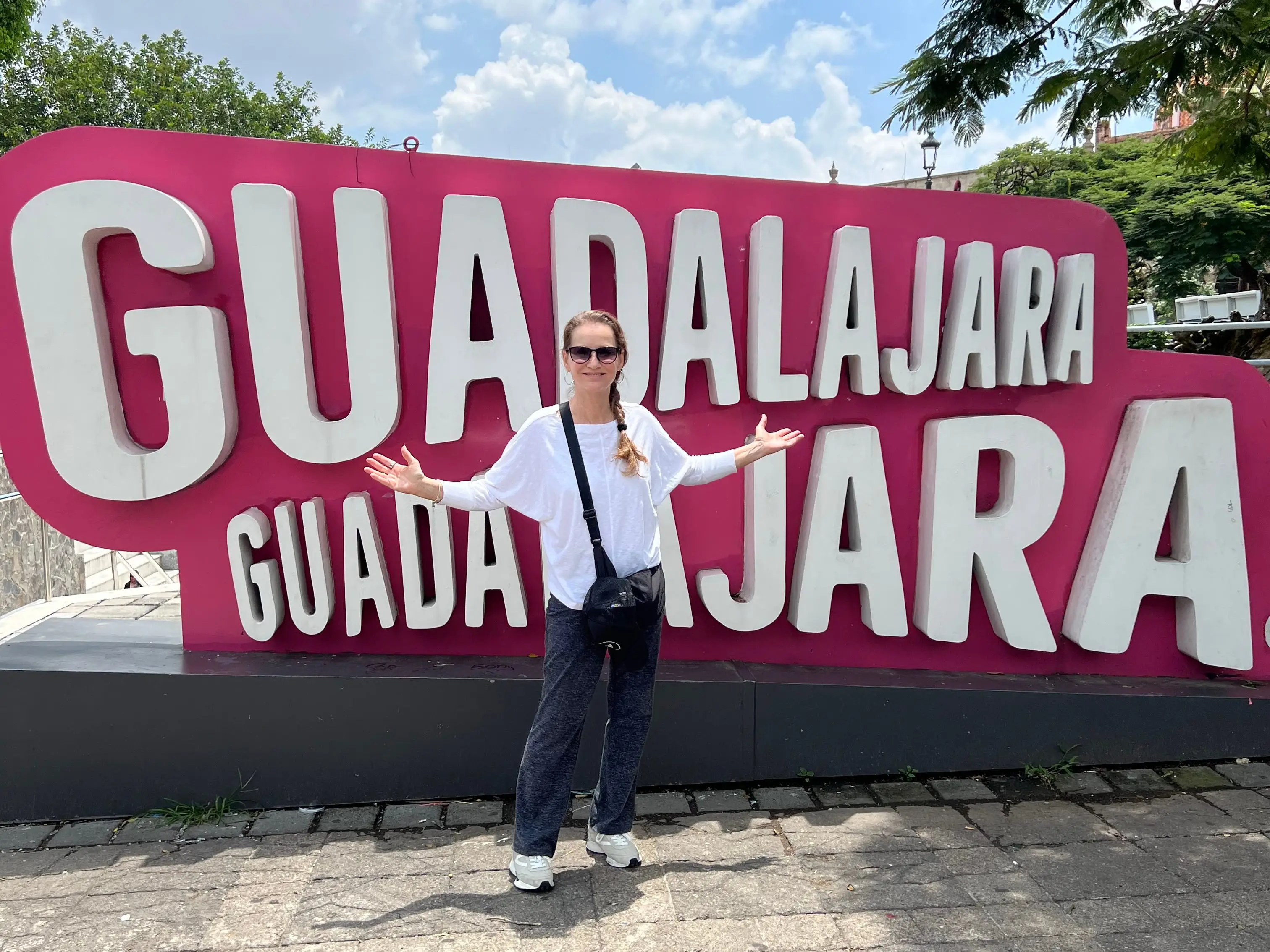 A woman standing next to a sign saying Guadalajara