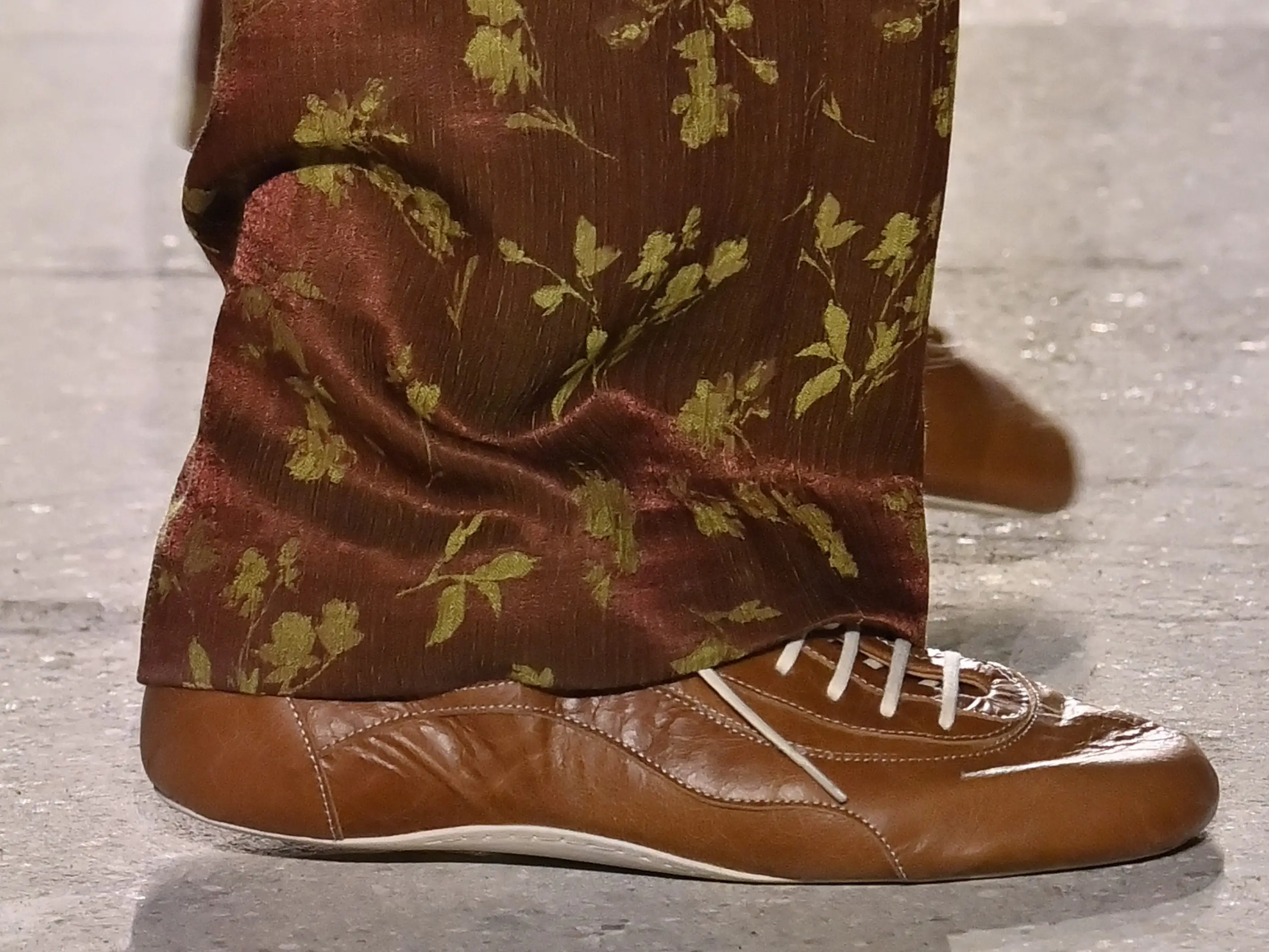 A model wears Dries Van Noten sneakers on a runway in January.
