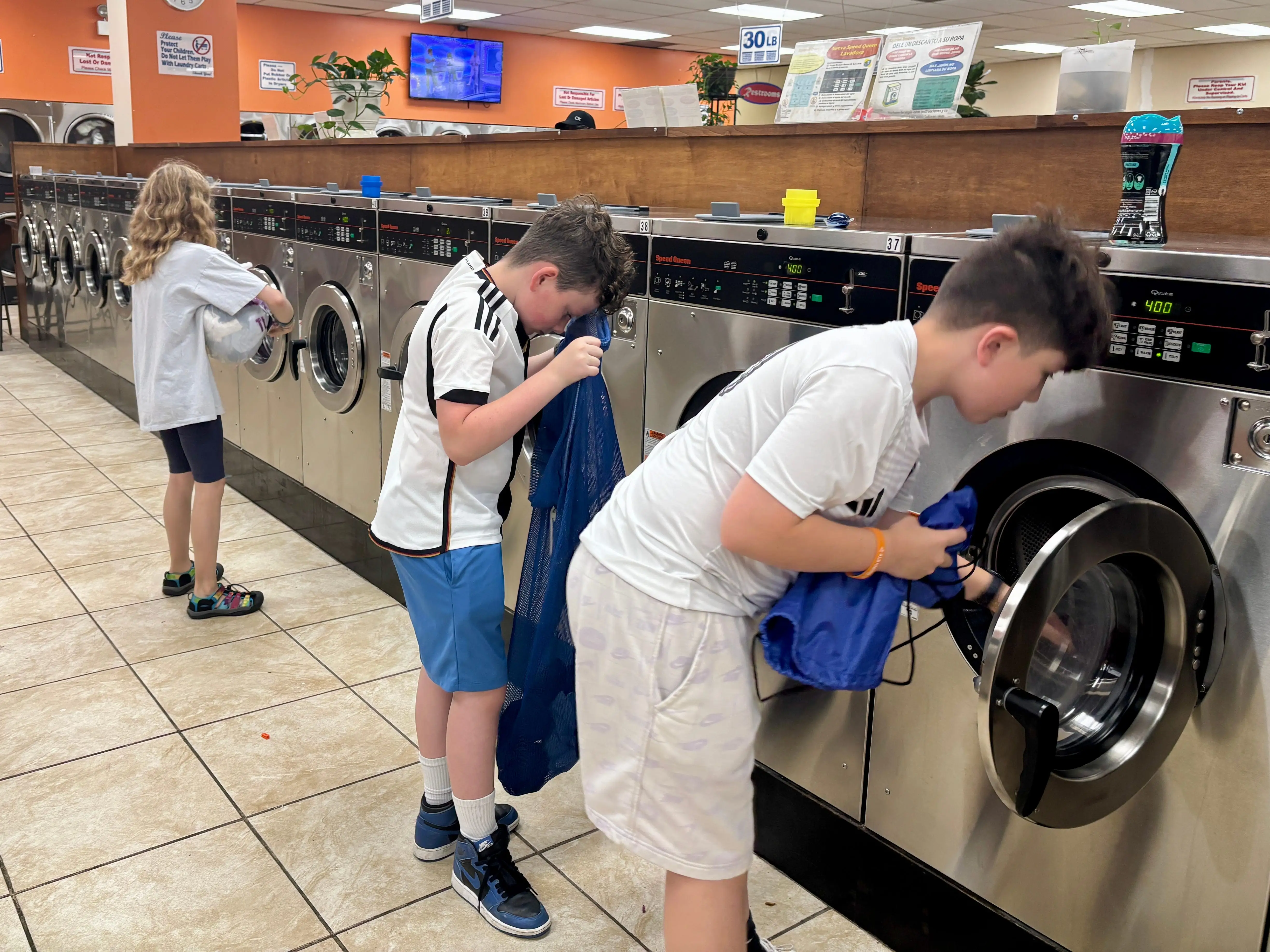 Kids doing laundry at laundromat