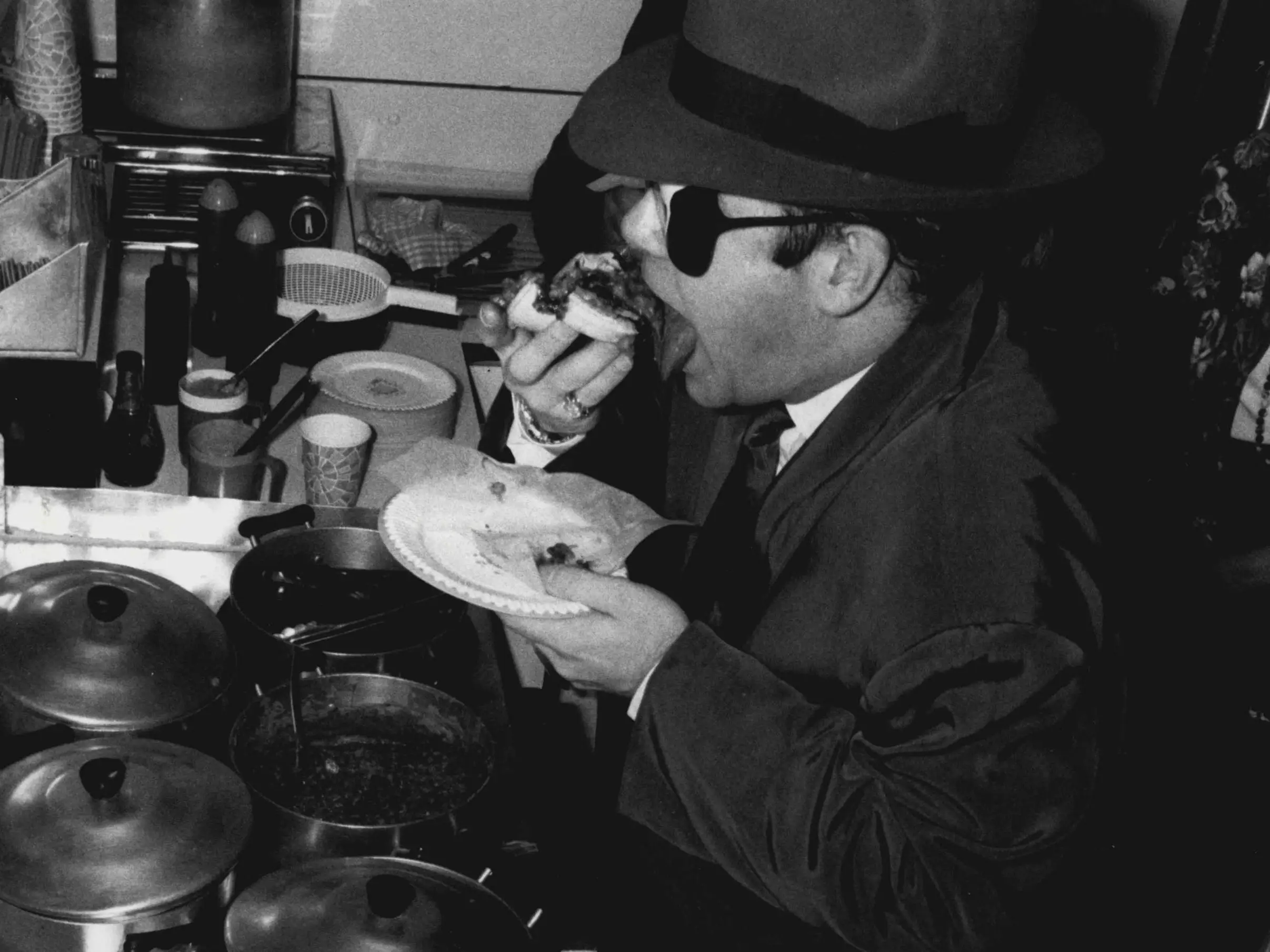 Elton John eats a sandwich.