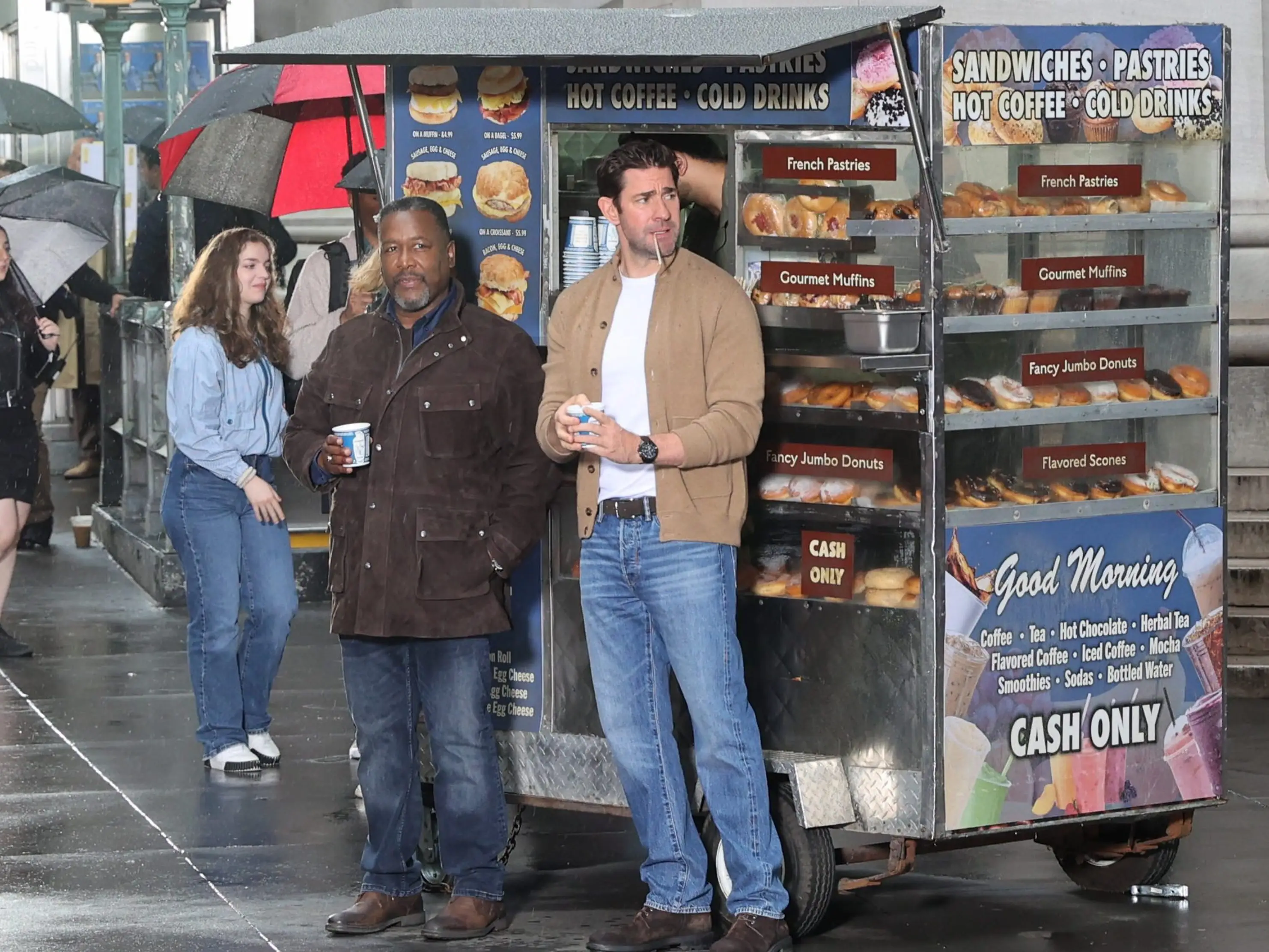 John Krasinski and Wendell Pierce in front of a sandwich stand while filming 
