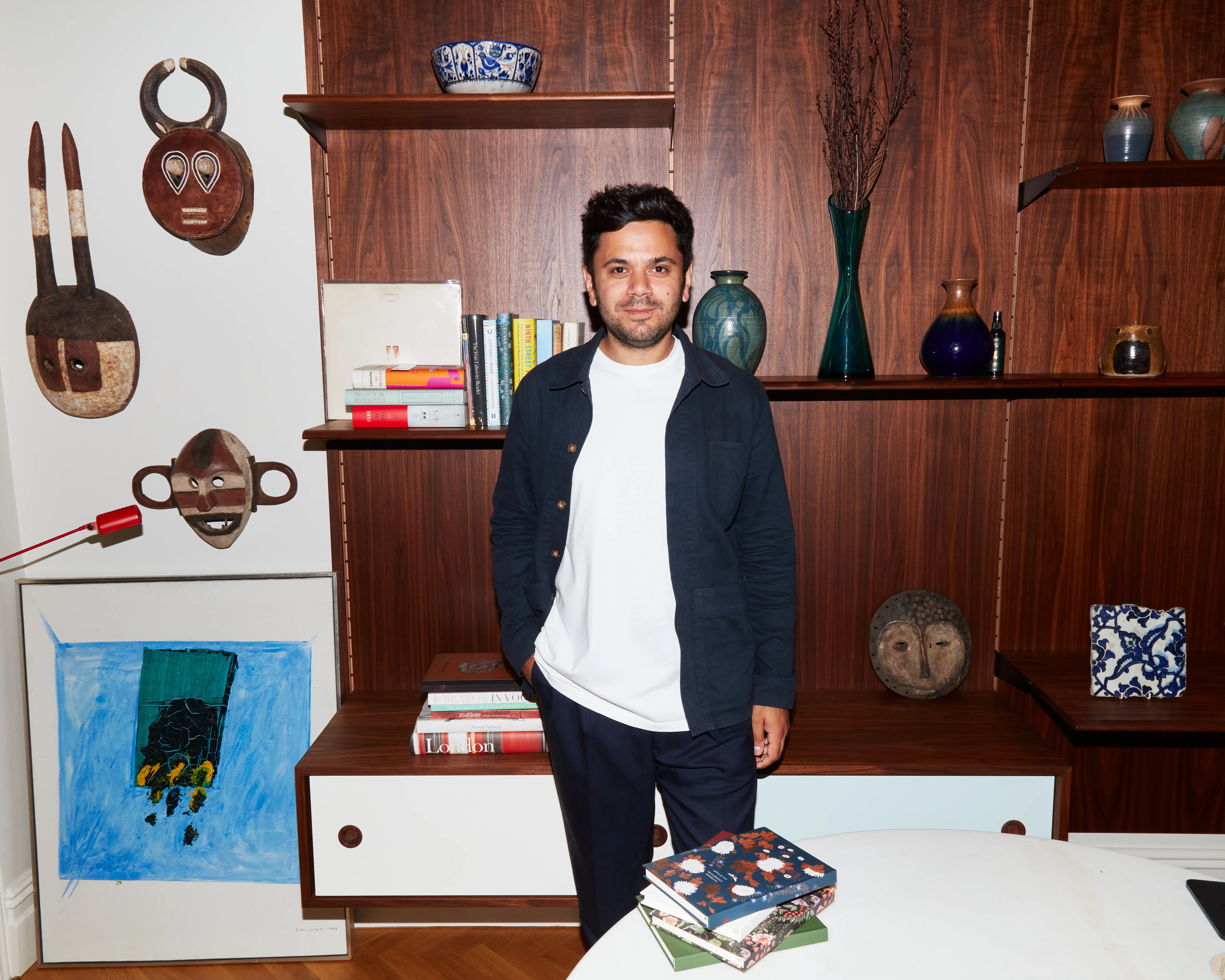 Papier CEO Taymoor Atighetchi stands behind a table with Papier notebooks placed on top of it.