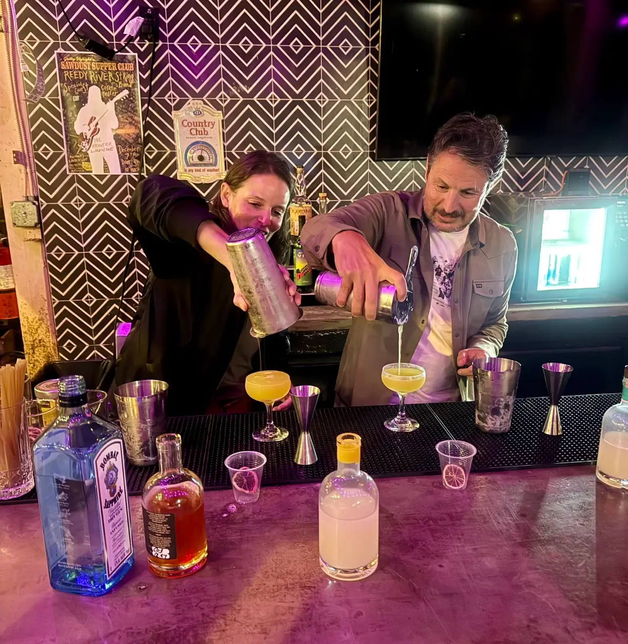 Man and woman pouring cocktails