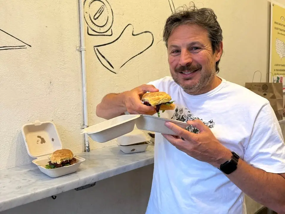 Man smiling, holding bisc