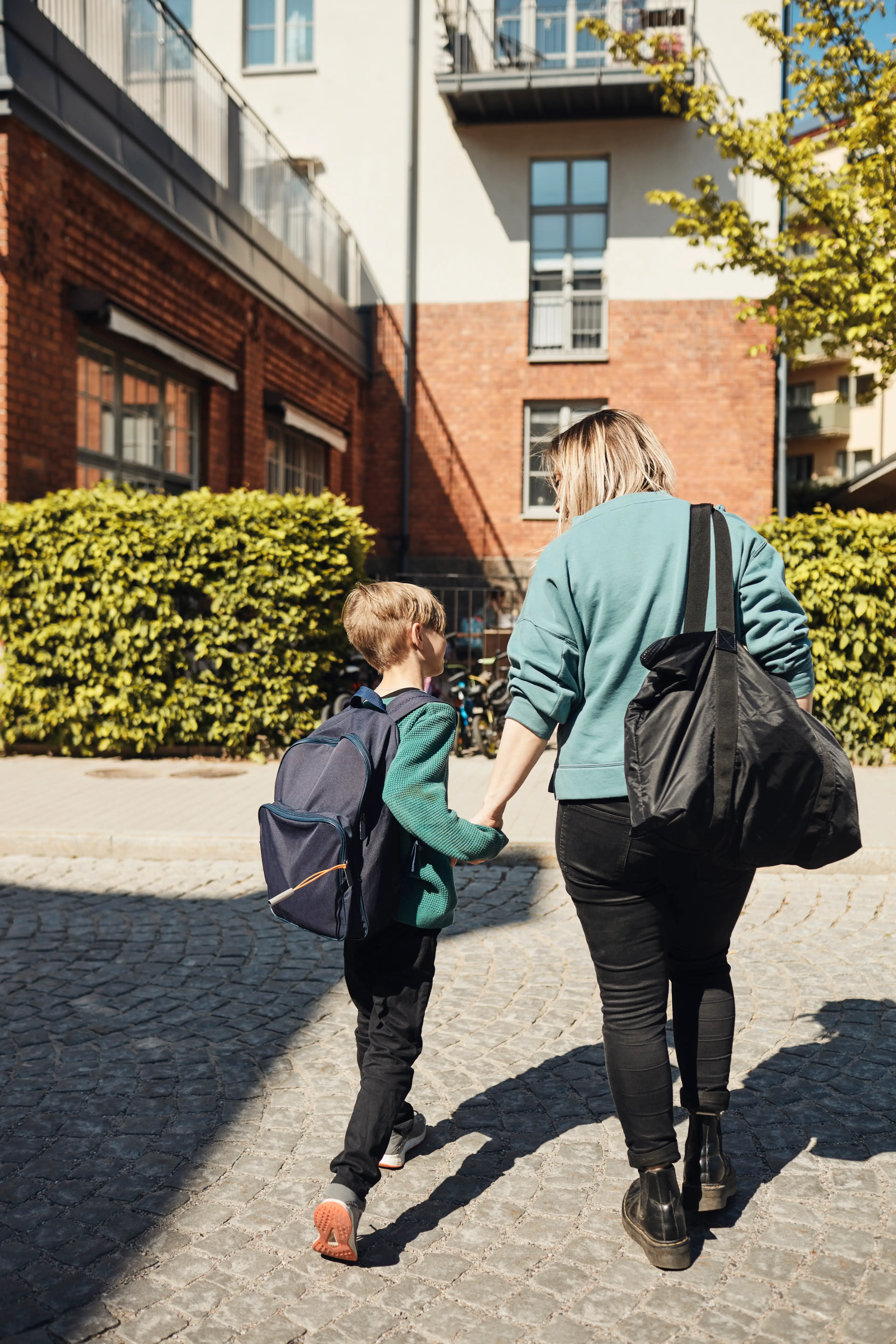 A mother and child walk together in a courtyard.