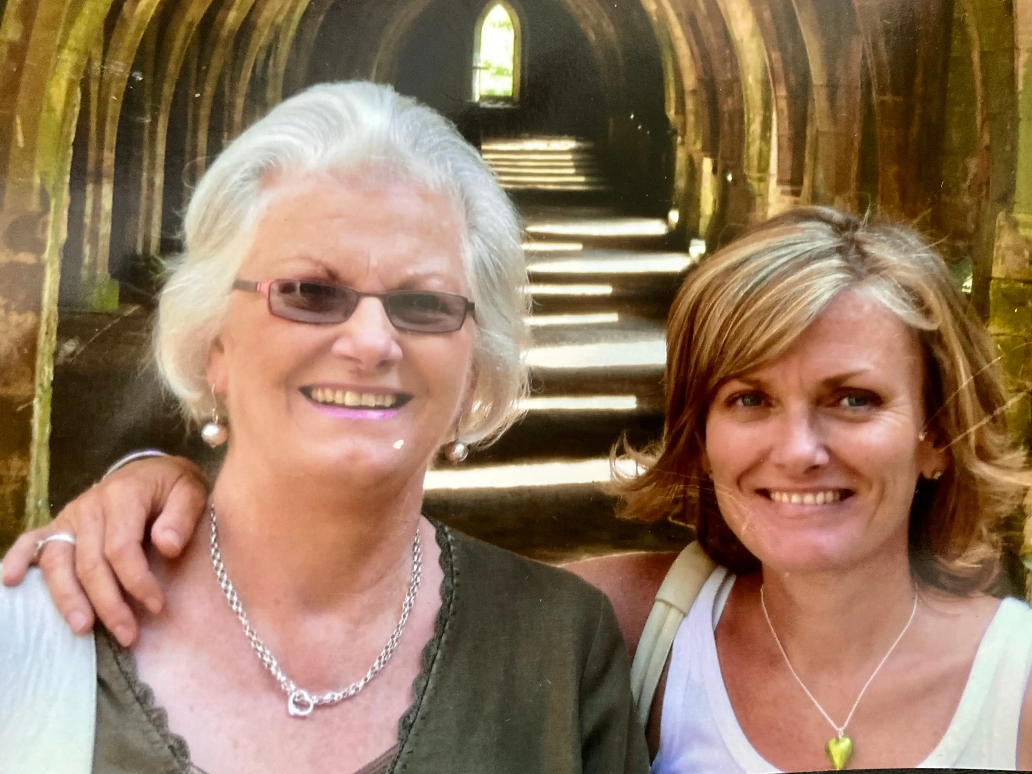 An older woman and her daughter smiling at the camera