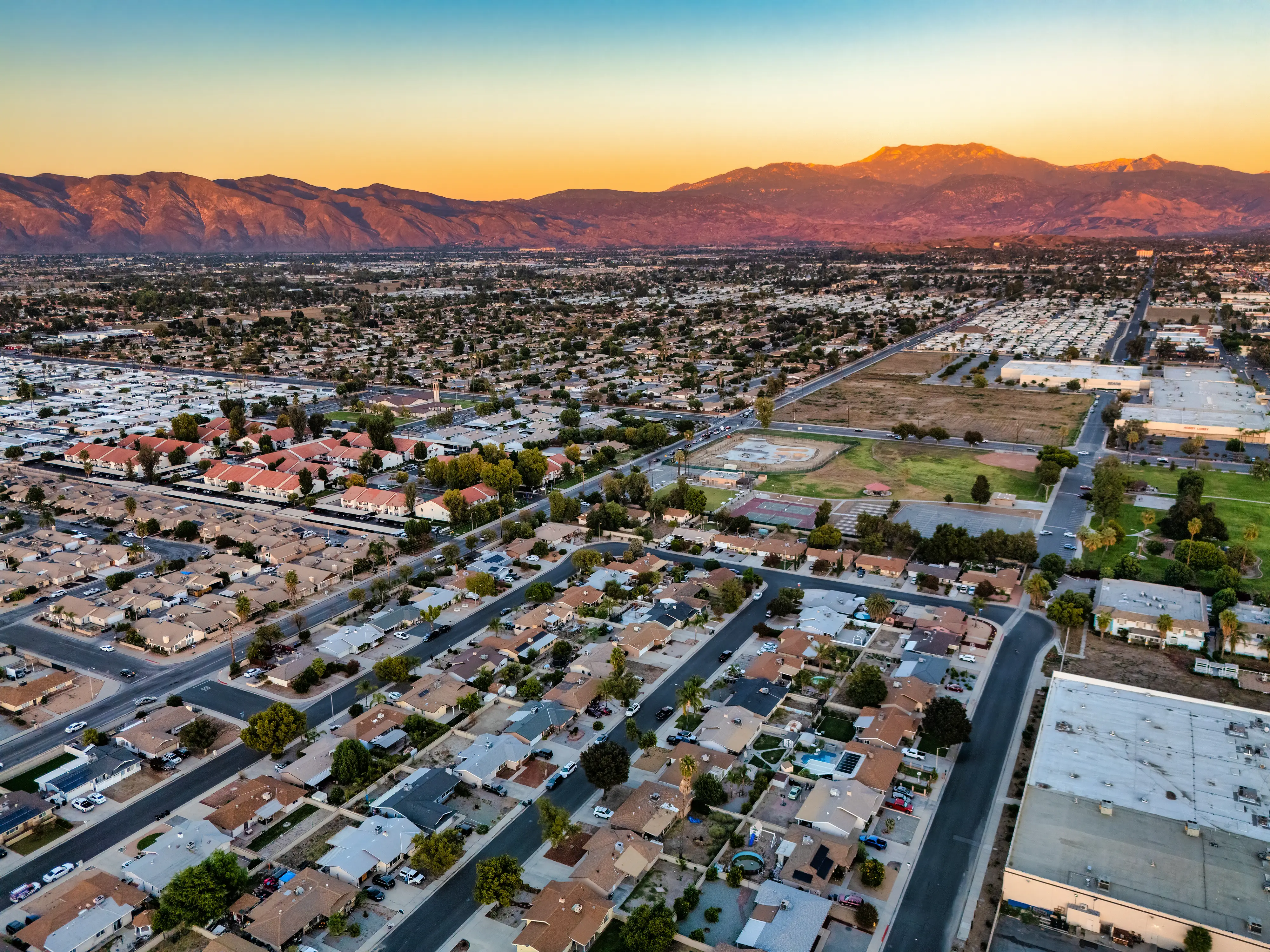 An aerial view of Hemet, California, with homes, and a large mountain range in the back.