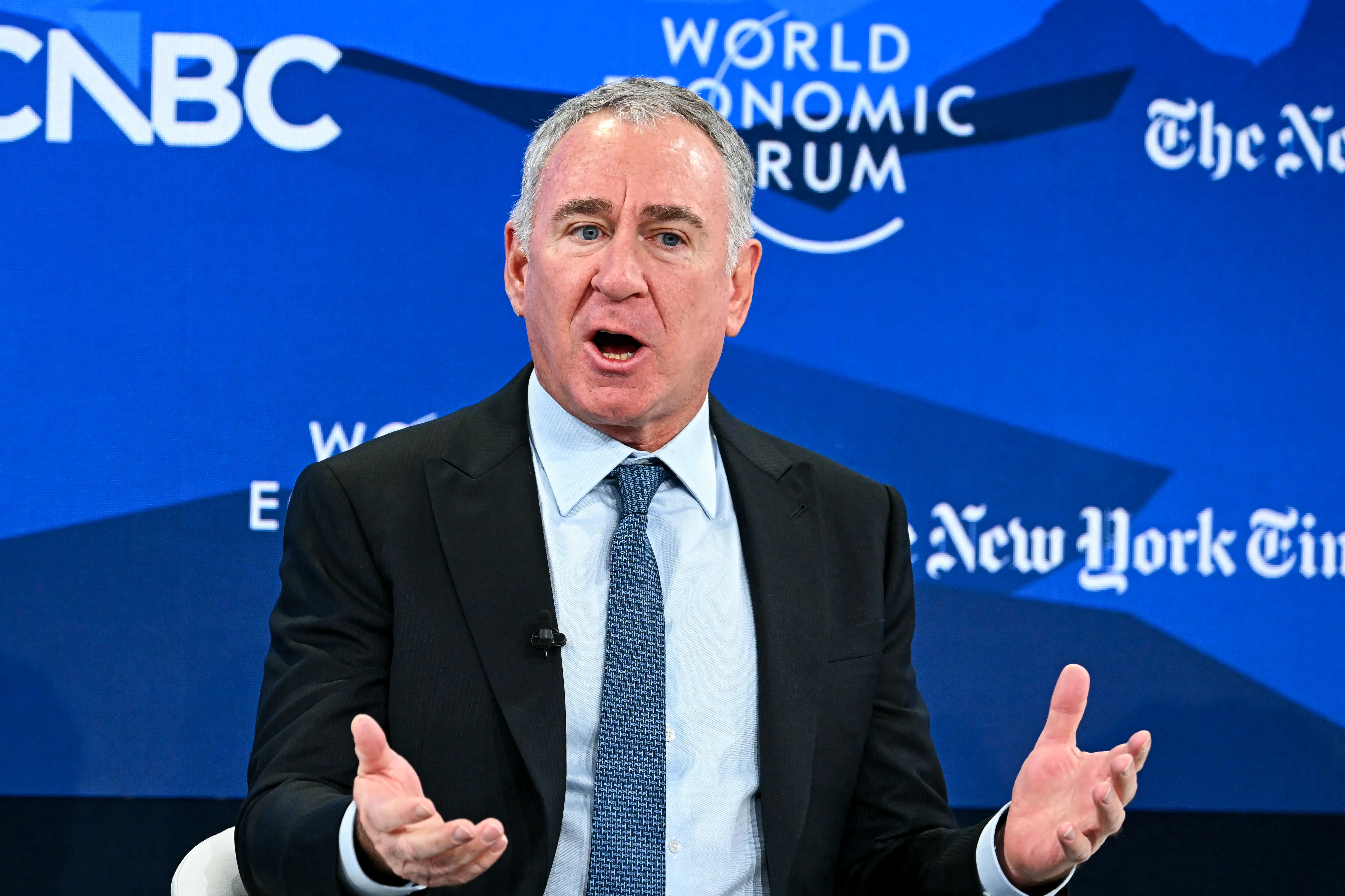 Ken Griffin speaks on stage in a black suit