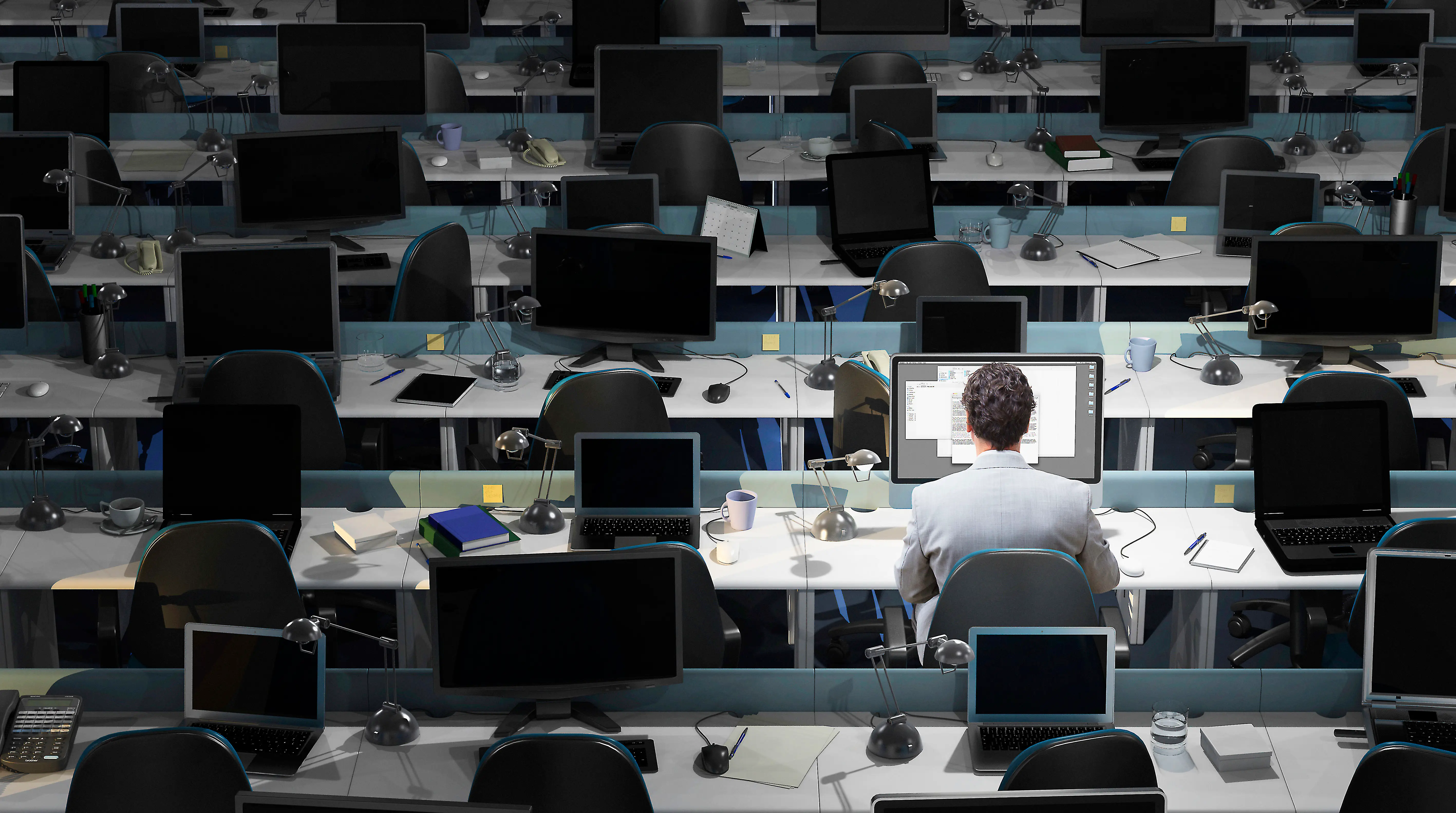 An office worker sits working in an empty office