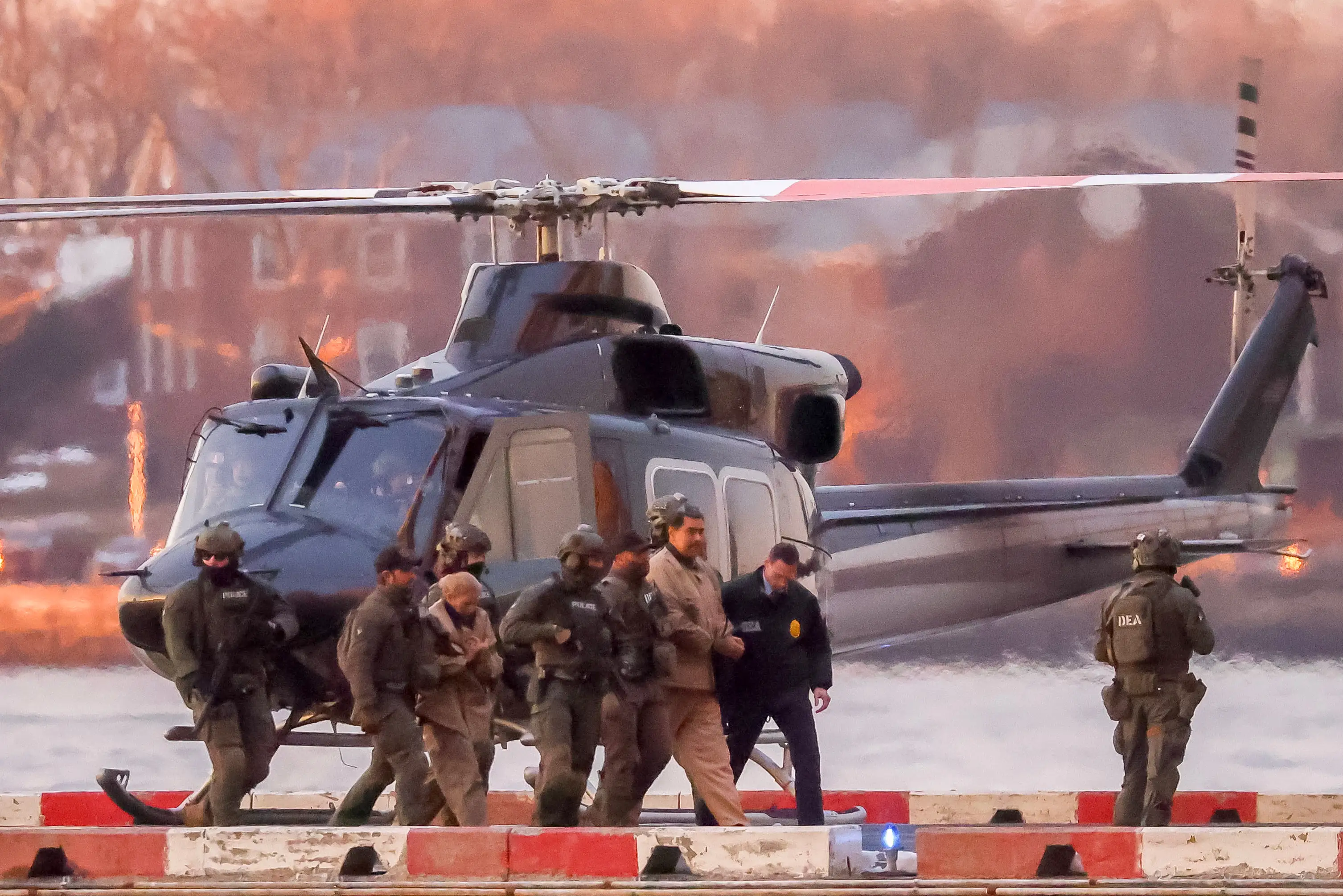 Nicolás Maduro surrounded by agents and soldiers near a helicopter.