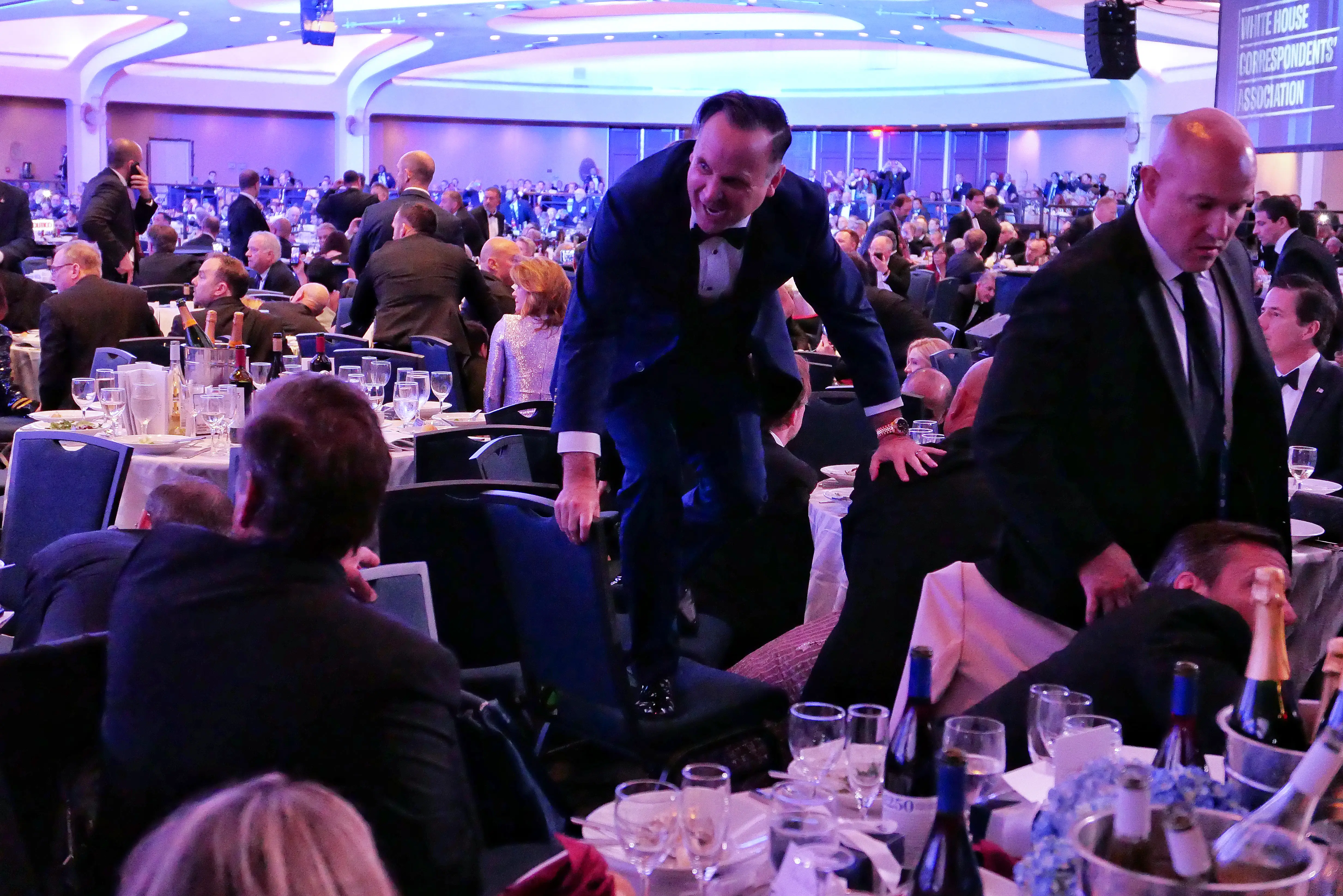 White House Deputy Chief of Staff Dan Scavino jumps over a chair during the incident at the White House correspondents' dinner.
