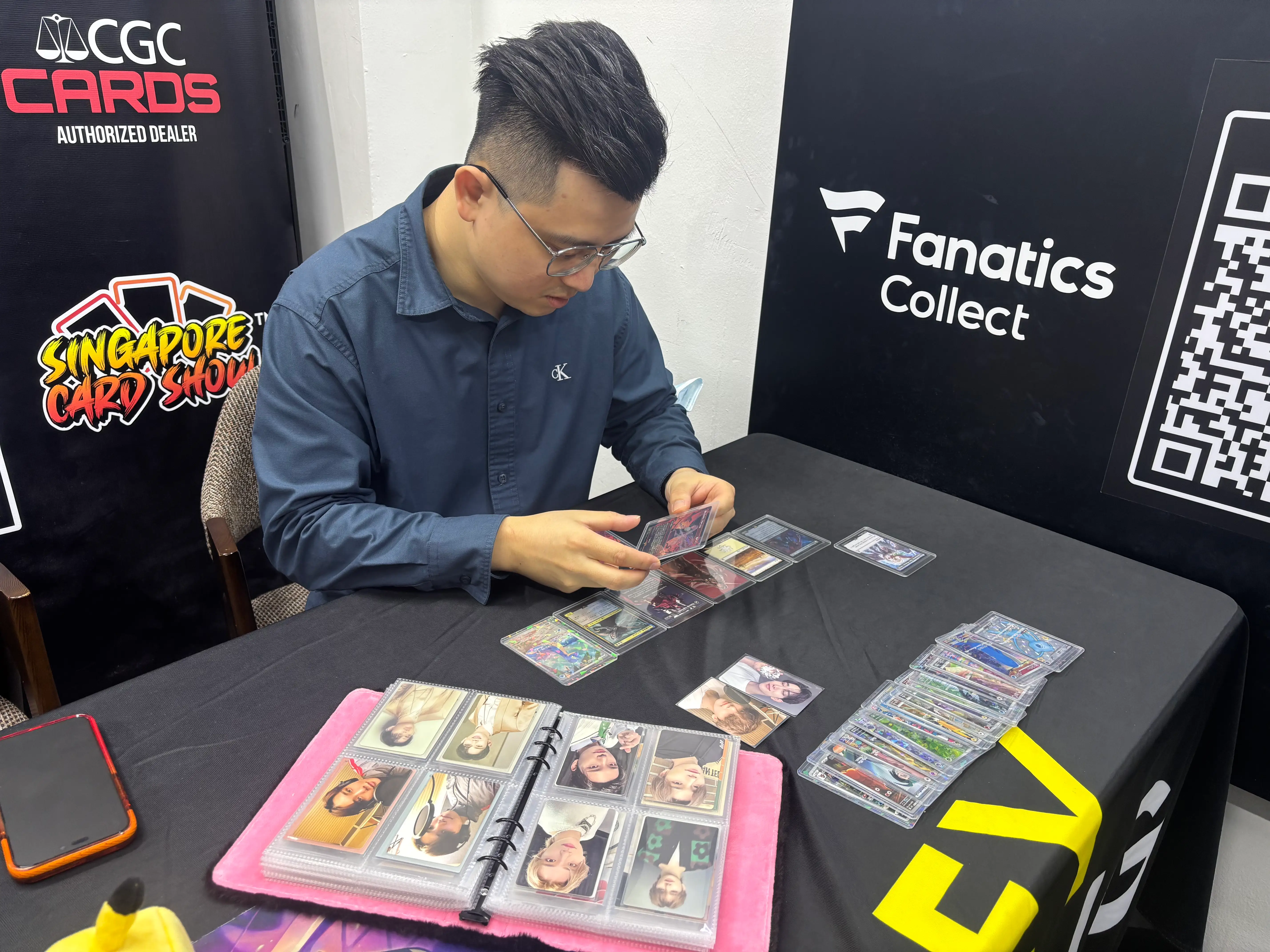 A picture of Johnathan Lim of Oxley Grading looking at my cards.