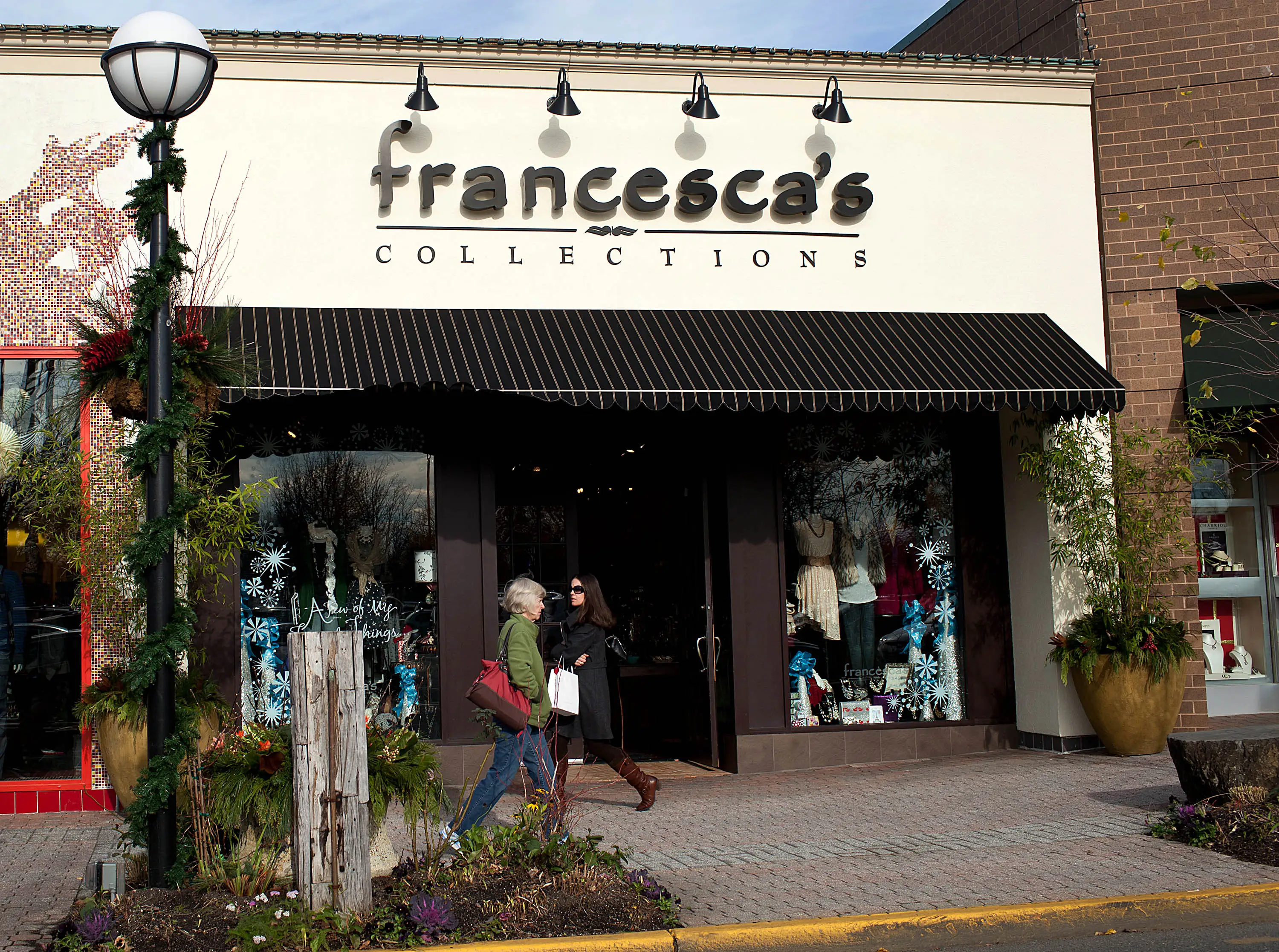 Shoppers pass in front of a Francesca's Collections store, a subsidiary of Francesca's Holdings Corp., in Shrewsbury, New Jersey, U.S., on Friday, Dec. 2, 2011.