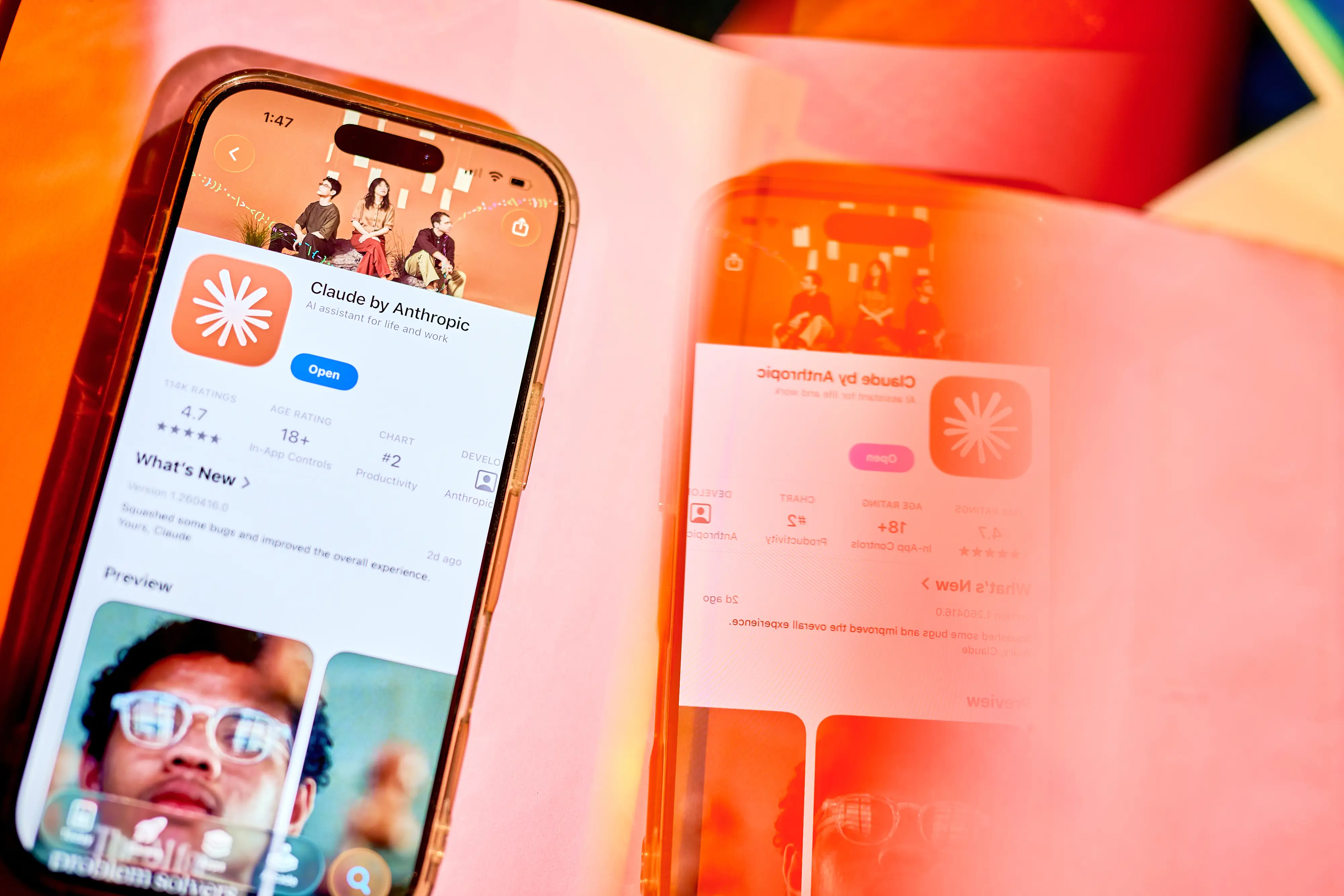 An iPhone is opened on the Claude by Anthropic page in the App Store.