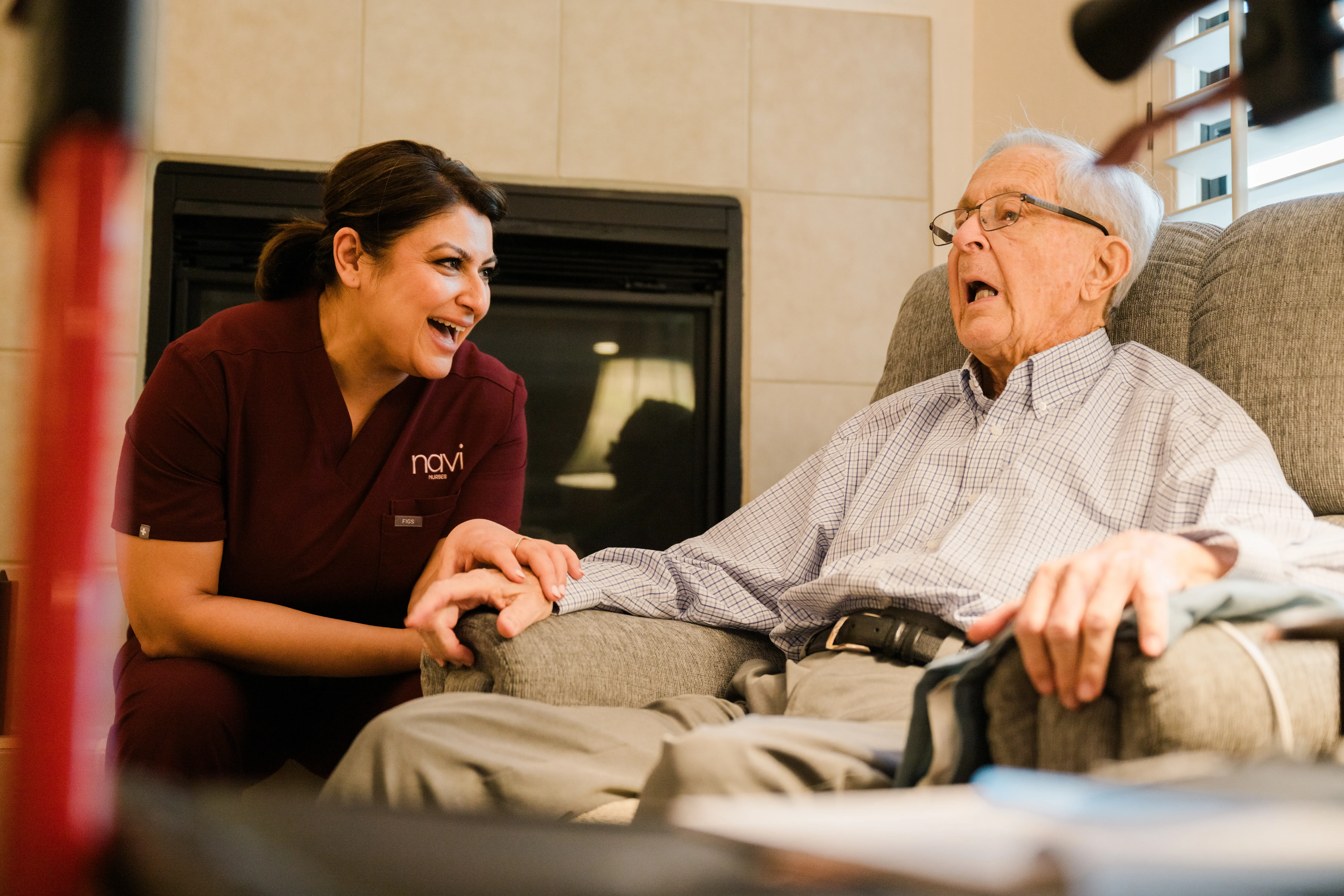 Jasmine sits and talks with a patient in his house.