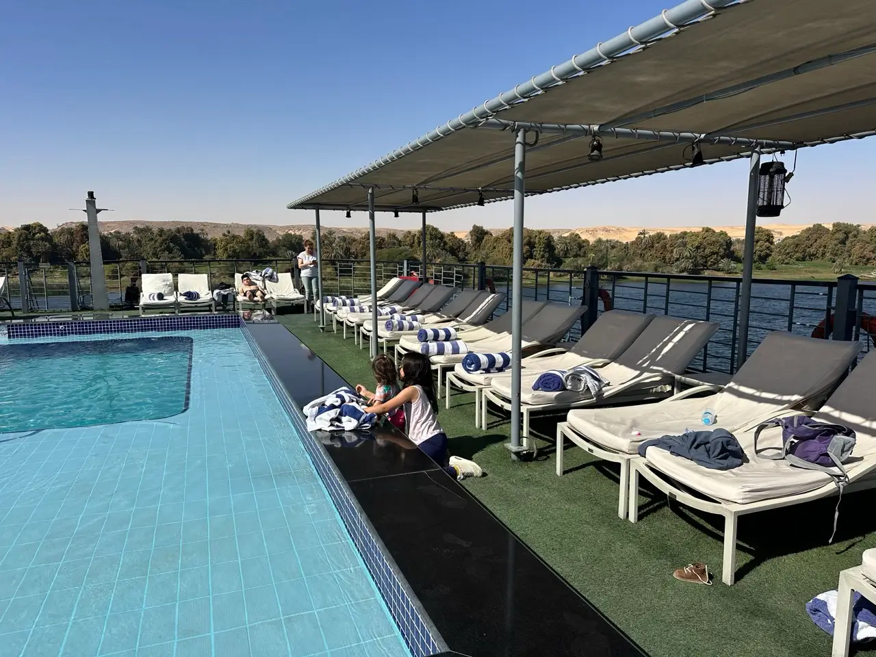 rooftop pool deck with covered loungers nearby