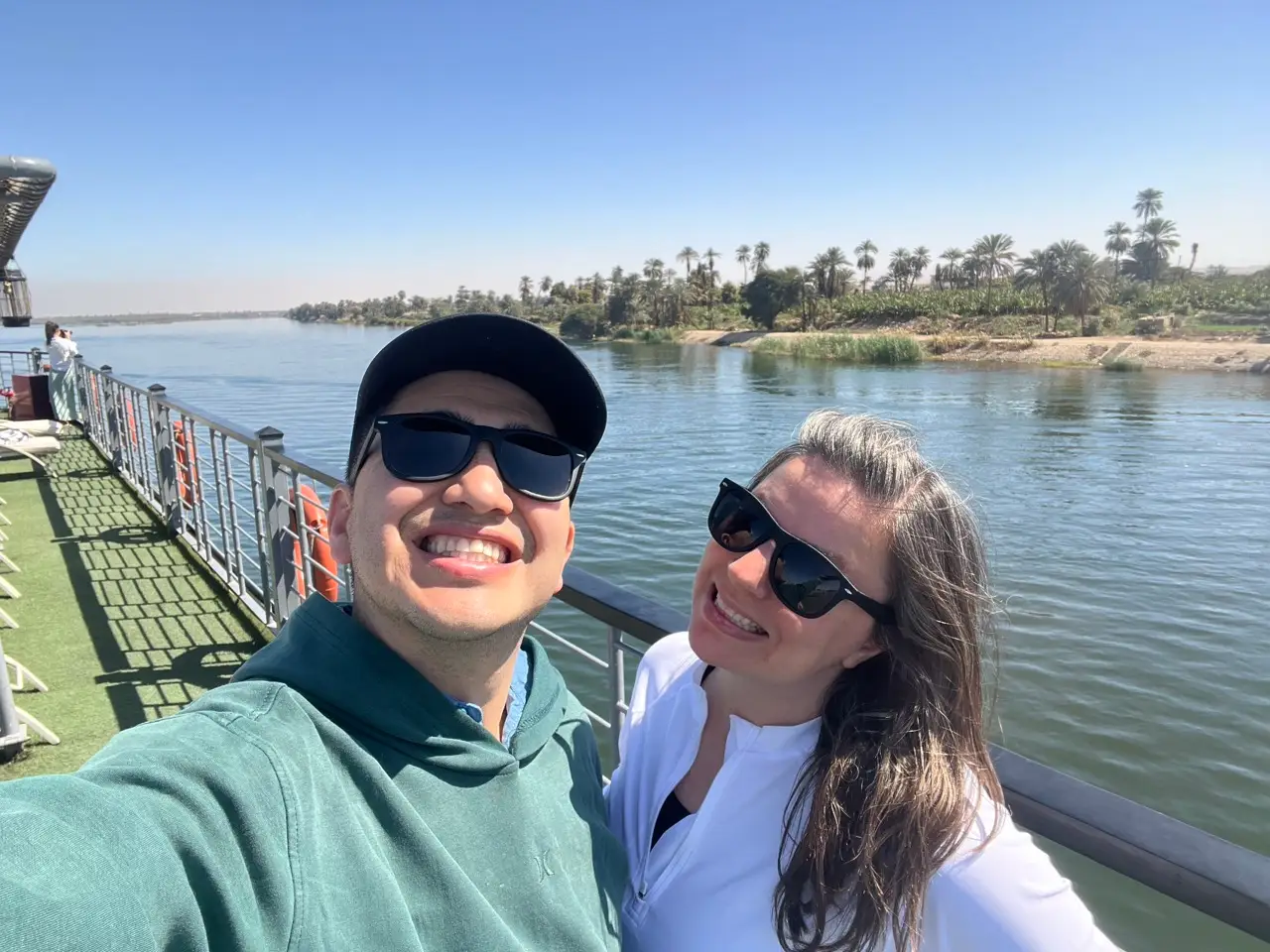 Two people with sunglasses smilin on river cruise