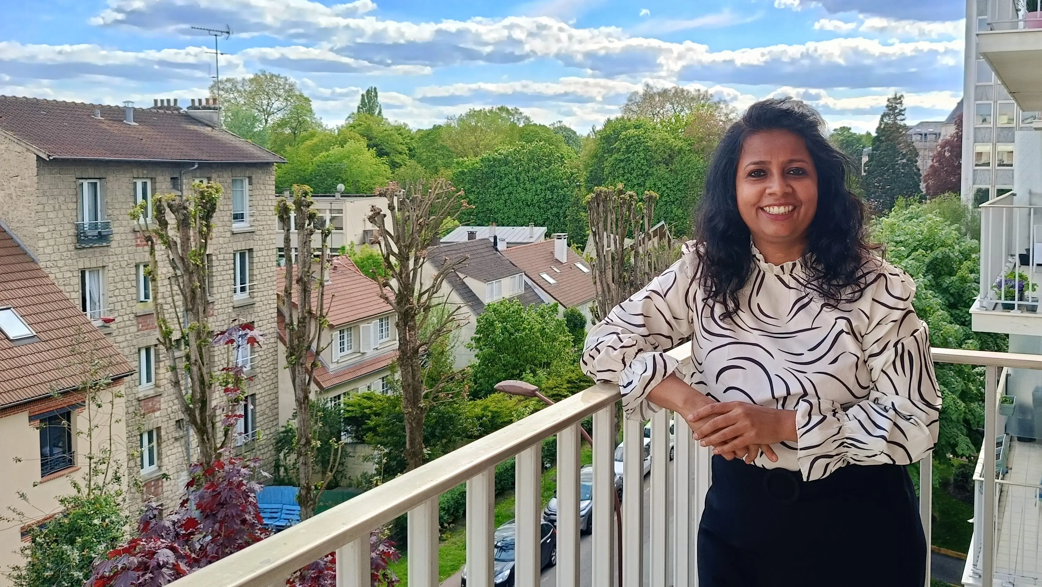 The author poses on a balcony.