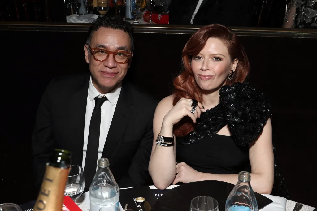 Fred Armisen, in a black suit, white shirt and black tie, and Natasha Lyonne,in a black dress, seated at the 77th Annual Golden Globe Awards.