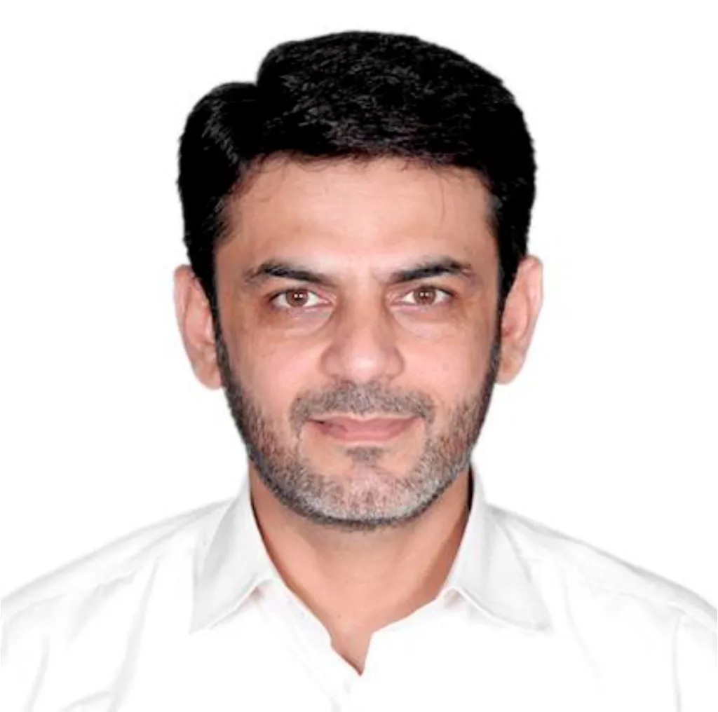 Headshot of a man with dark hair and a beard, wearing a white collared shirt.