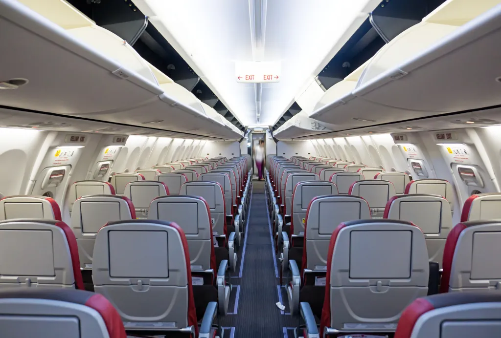 Rows of seats and aisle of a commercial airplane.