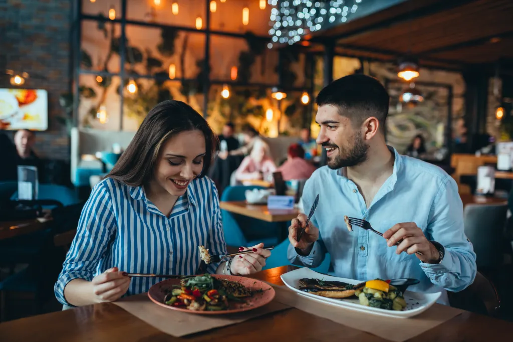 A romantic couple having lunch in a restaurant.