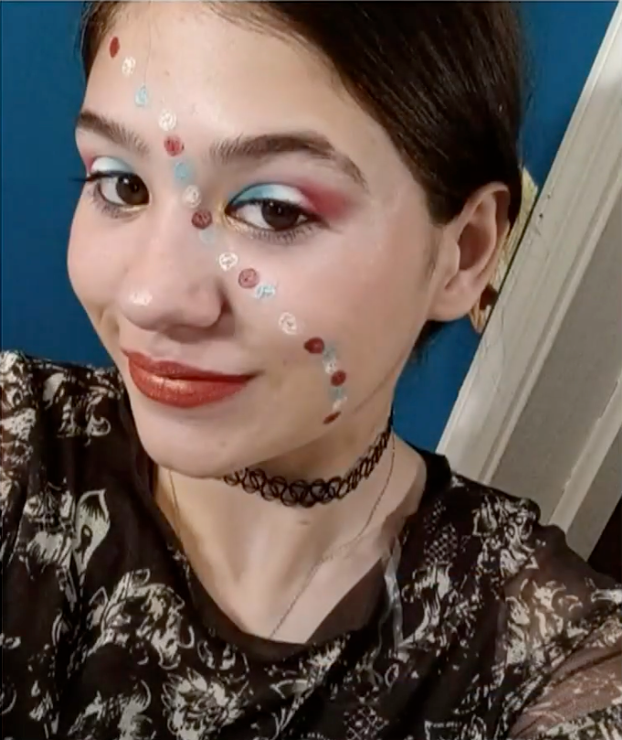 Ashlee Holmes wearing elaborate makeup and a choker.