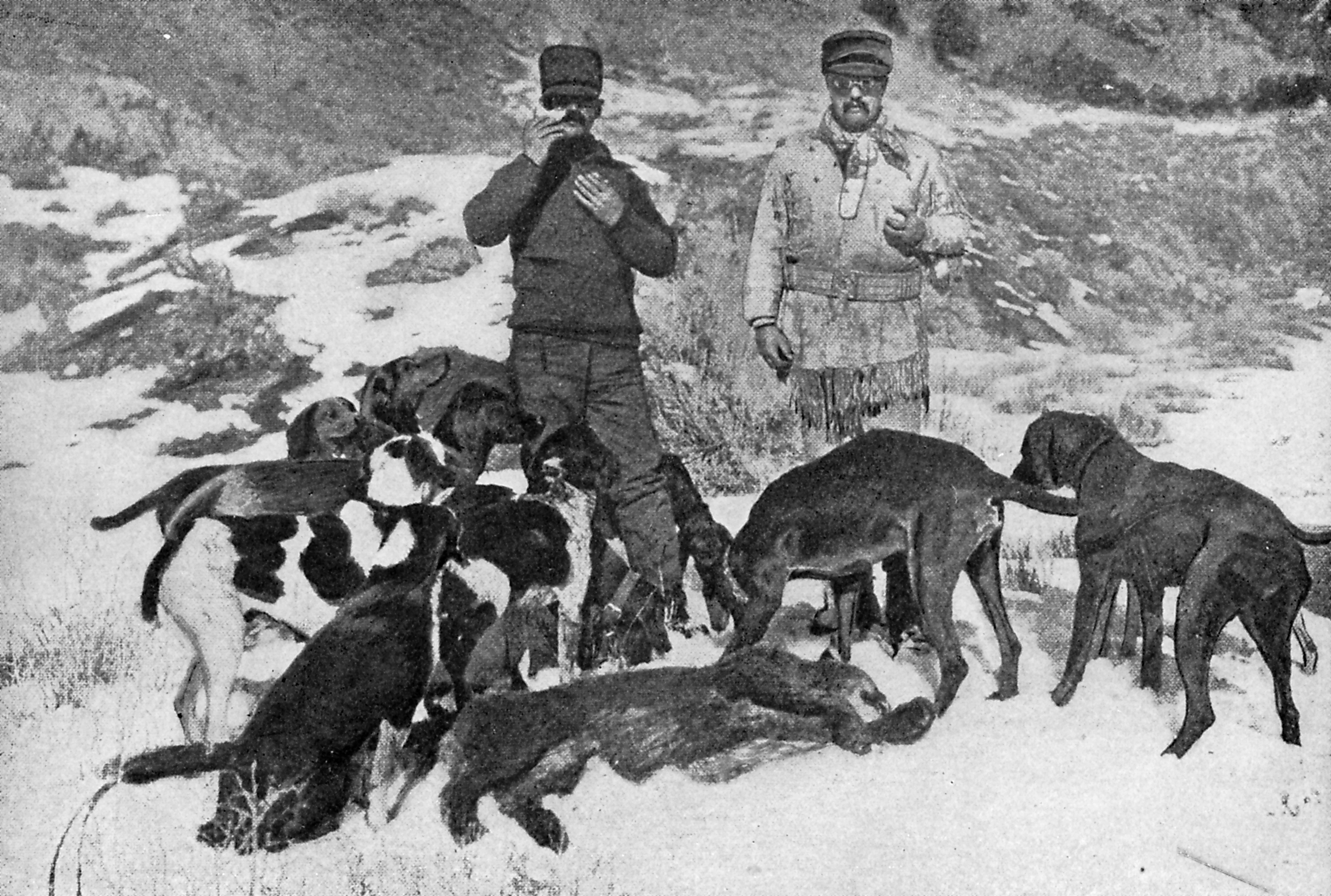 Theodore Roosevelt and Peter Goff surrounded by 7 black dogs.