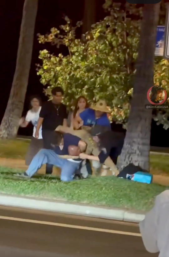 Man in uniform being brutally beaten by a group of people.